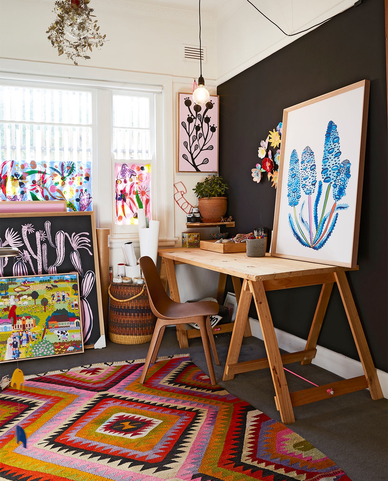 Madeleines atelier bevindt zich aan de voorkant van het huis. Bureau via eBay. Stoel Odger Ikea. Het ingelijste handwerklandschap is gemaegiakt door Madeleines moeder, andere kunstwerken van Madeleine zelf. Overig onbekend. vtwonen binnenkijk special zomerhuizen 07-2021 | productie &amp; styling Living Inside | fotografie Armelle Habib