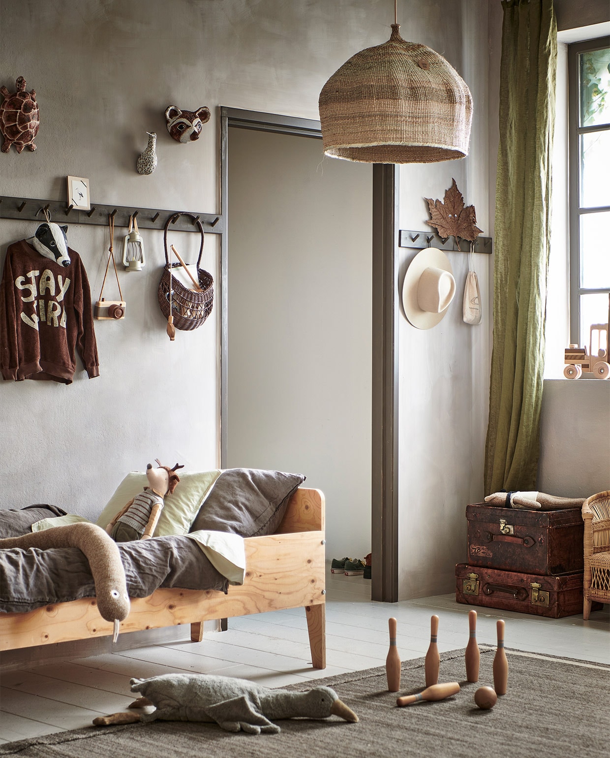 Muurverf Elkhorn, prijs op aanvraag (bauwerkcolour.com). Houten juniorbed Crisis, onbehandeld (pietheineek.nl). Houten kapstok van Iris Hantverk, 67×7,5 cm(arket.com), geschilderd in de kleur Peppery Black No. 71 (vestingh.nl). Vloerkleed Hojet bruin, 170×240 cm (ikea.nl). Beddengoed Junior Bedding van Studio Feder in kleur Moss Green, organisch katoen, 100×140 cm, hoed Old Habits Die Hard, houten handgemaakt visspel, bowling set van Wooden Story (zoenvoorgust.com). Knuffel slang van Ferm Living, knuffel muis van Maileg, knuffel gans large van Senger Naturwelt, teddybeer (op koffers) van Ferm Living (storeofdaydreams.com). Houten speelgoedcamera Fanny &amp; Alexander (elenfhant.nl). Houten lijst met ooievaarskaart (keizerin.nl). Hanglamp mand Ilala palm (couleurlocale.eu). Papier-maché dierenkoppen gemaakt door Babette Hofstede, prijs op aanvraag (babetteswereld.com). Rotan wall basket Emilou in kleur Dark Brown (merilou.nl). Lantaarn onderdeel van Explorer set (zarahome.com). Linnen gordijn in donker kakigroen, set van 2 (hm.com). Houten vorkheftruck van Goki (lanoeka.com). Oude leren koffers(burbri.nl). Stoel Malawi Kids Chair van People of the Sun (archive-store.nl). Overig privébezit. vtwonen special 13-2021 | styling Kim van Rossenberg | fotografie Sjoerd Eickmans