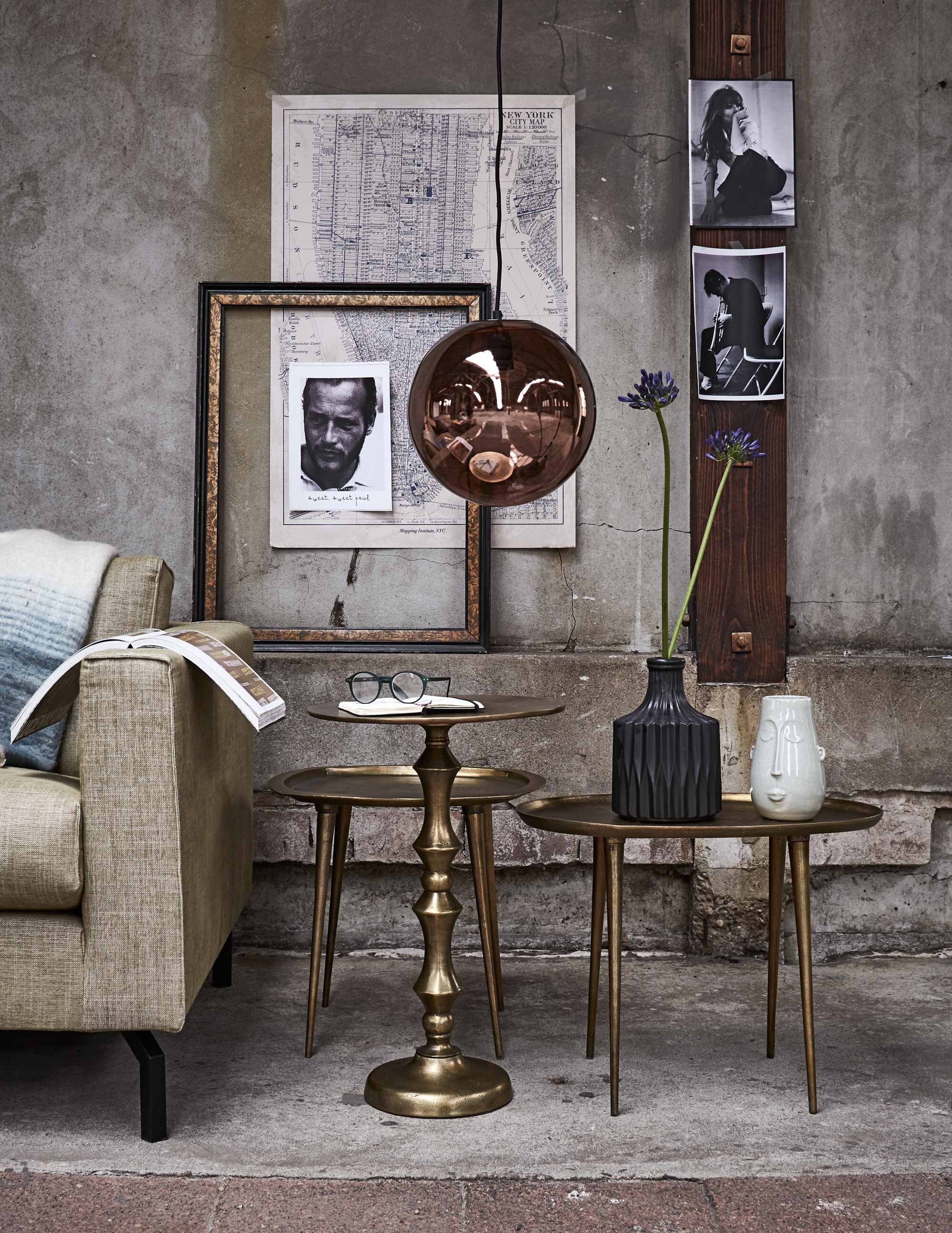 Bijzettafels Copper Ova, Copper Square en Copper Chique (Pols Potten). Koperkleurige bollamp, zwarte vaas (HK Living). Vaas met gezicht (Loods 5). Goud-zwarte lijst (Neef Louis). 2,5-zitsbank Bruce (Bodilson). Plaid (De Weldaad). Overig privébezit.