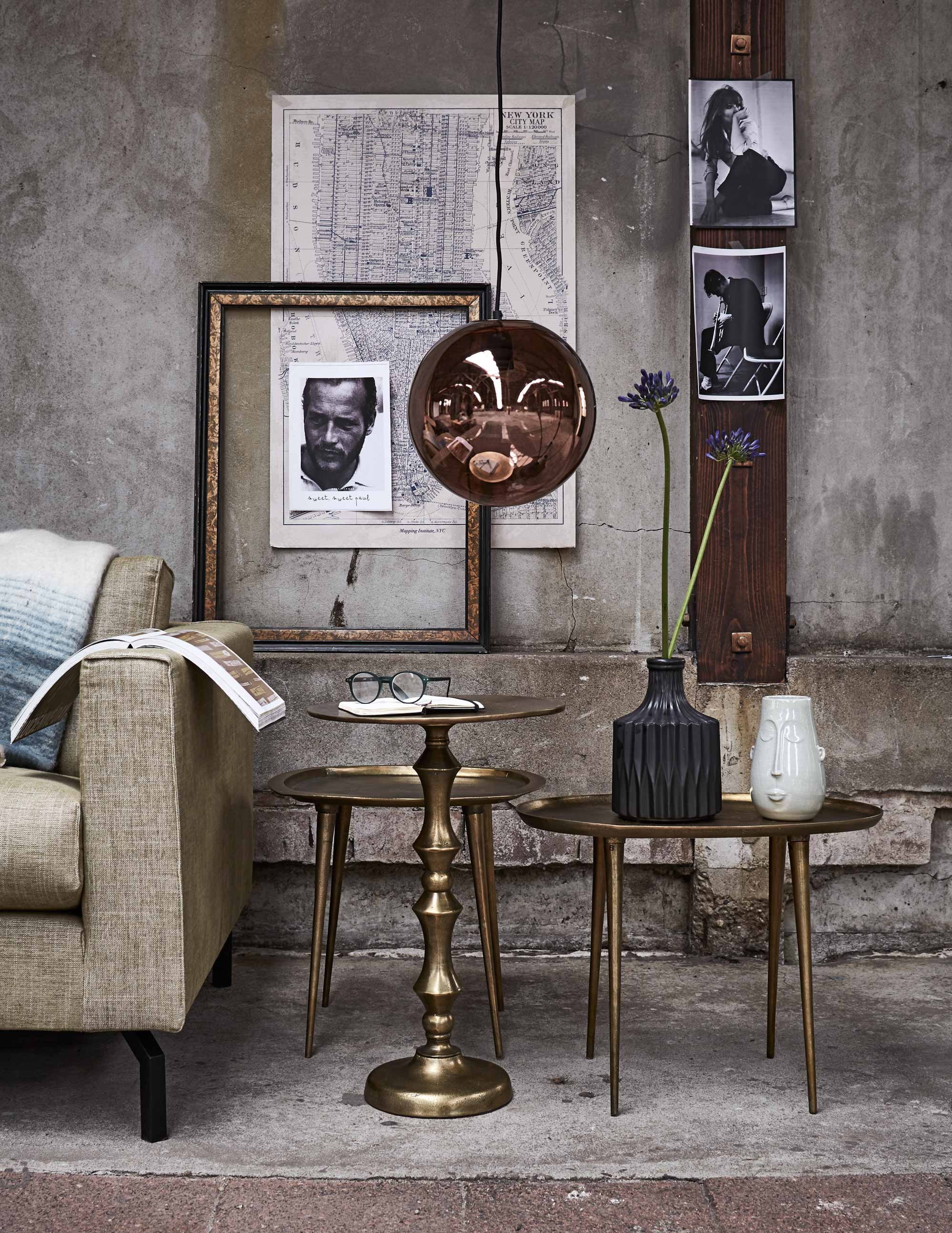 Bijzettafels Copper Ova, Copper Square en Copper Chique (Pols Potten). Koperkleurige bollamp, zwarte vaas (HK Living). Vaas met gezicht (Loods 5). Goud-zwarte lijst (Neef Louis). 2,5-zitsbank Bruce (Bodilson). Plaid (De Weldaad). Overig privébezit.