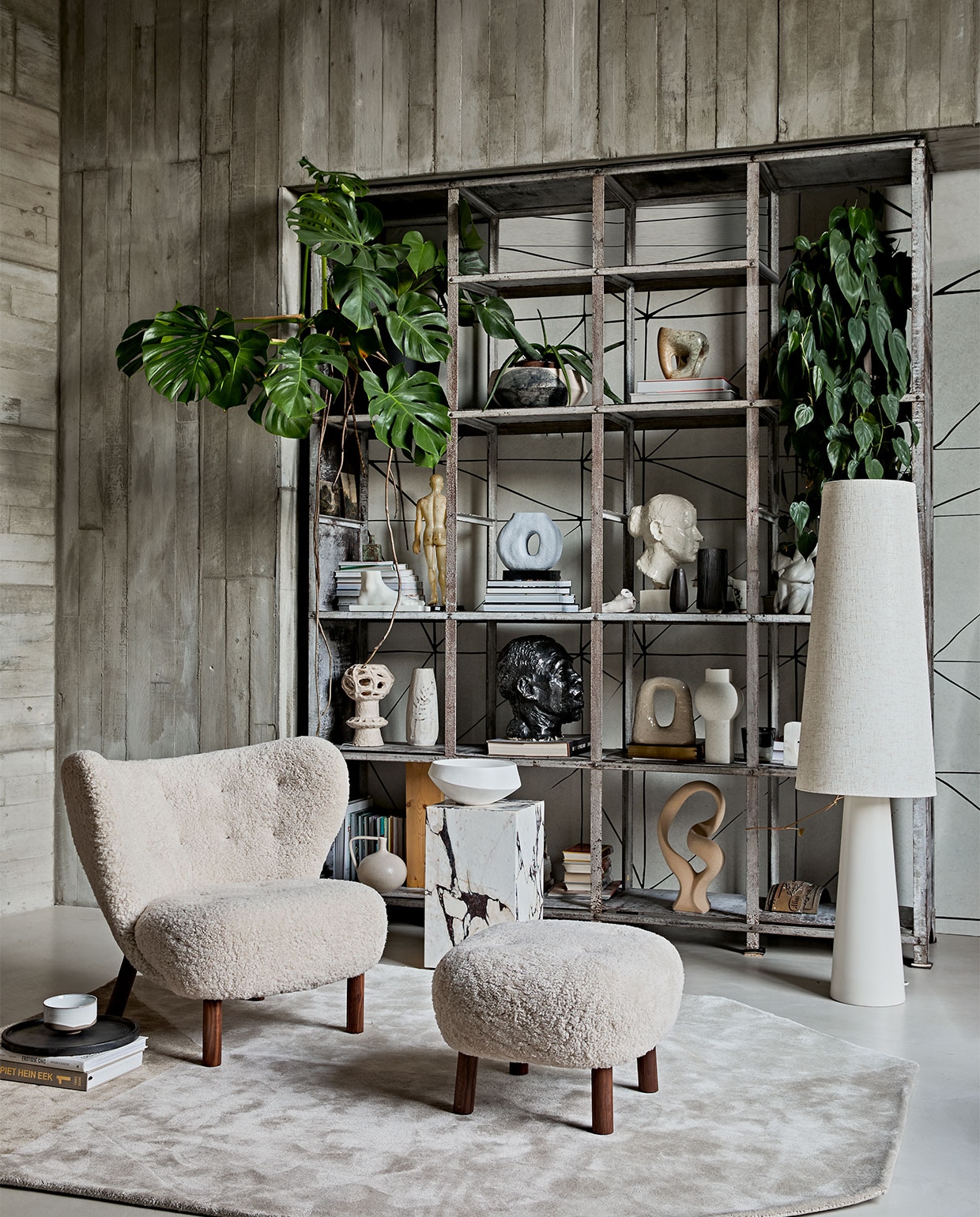 Keramieken vloerlamp retro cone xl, 40×140 cm (Øxh) € 449,- (hkliving.nl). Fauteuil en voetenbank met schapenvacht Little Petra van &amp;Tradition € 6113,-(kasstoor.nl). Vloerkleed Volume van Fest Amsterdam € 699,-, dienblad van Zone Denmark. 35 cm (Ø) € 50,-, kom van Merci n°1 van Serax, 12,5 cm (Ø) € 16,65 (vtwonen.nl). Marmeren bijzettafel Plinth Tall van Menu, 30x30x51 cm (lxbxh) € 999,95 (designtales.nl). Erop: schaal € 59,95 (urbannatureculture.nl). Behang achter kast JO2703-2 Tres Tintas, Cuzco per m² € 45,- (rebelwalls.com). In de kast, van onder naar boven: crème vaas met oor € 34,95 (hkliving.nl). Ecru sculptuur Stoneware van Bloomingville € 85,- (vtwonen.nl). Zandkleurige keramieken kaarsenstandaard Arch van Malwina Kleparska € 275,- (studio-yen.com). Vaas speckled round, 30 cm (h) € 39,95, polystone voet € 59,95 (hkliving.nl). Blauwe vaas met gat € 37,95 (vtwonen.nl). Stenen sculptuur € 900,- (lisette­leegwater.nl). Vintage hoofden en overige objecten (vintagehoarder.com). Wandbekleding en kast van locatie. vtwonen 02-2021 | styling Cleo Scheulderman | fotografie Jeroen van der Spek