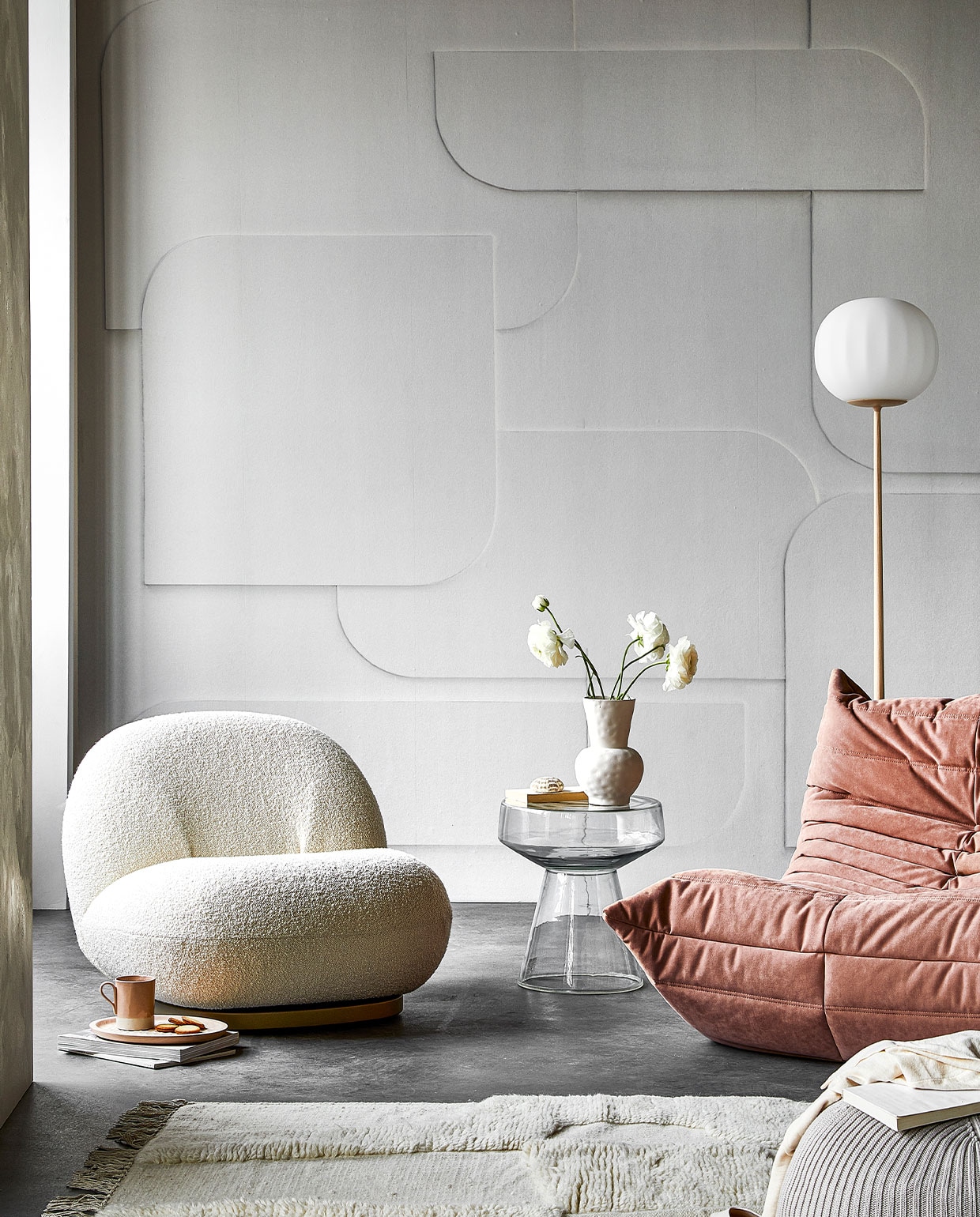 Digitaal behang Soft 3D light grey, 6 banen van 280×50 cm, totaal (lxb) 280×300 cm € 149,-. M.m.v. kasstoor.nl (witte fauteuil, roze fauteuil, vloerlamp), homestede.nl (houten dienblad, poef), paviljoennoord.com (mok, shirt), loods5.nl/design (glazen bijzettafel), zara.com (vaas, schoenen), hm.com (vloerkleed), pure-original.nl (muurverf Freso in kleur Sea Salt). Overig privébezit. vtwonen 05-2021 | productie Tanja Saarberg | styling Danielle Verheul | fotografie Peggy Janssen | assistentie Niels Kist, Danique van Rijn