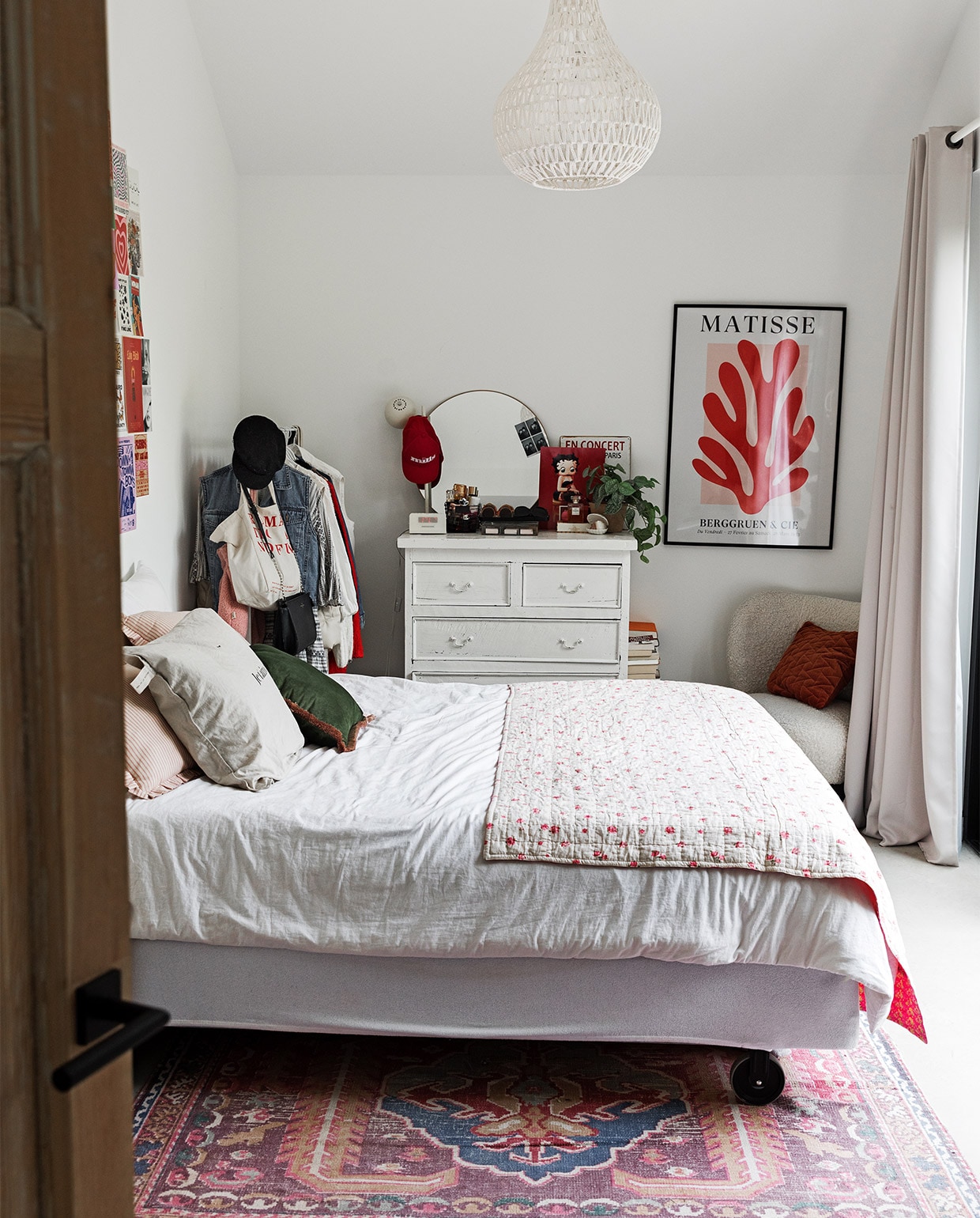 Muurkleur Ral 9016, collage Pinterest uitgeprint bij Albelli. Bijzettafel Burbri Antiek. Kussens Blokker en Zusss. Bed, beddengoed en kledingrek Ikea. Sprei gekregen. JA | vtwonen 12-2022 | styling Ilona Jongepier  | fotografie Dana van Leeuwen