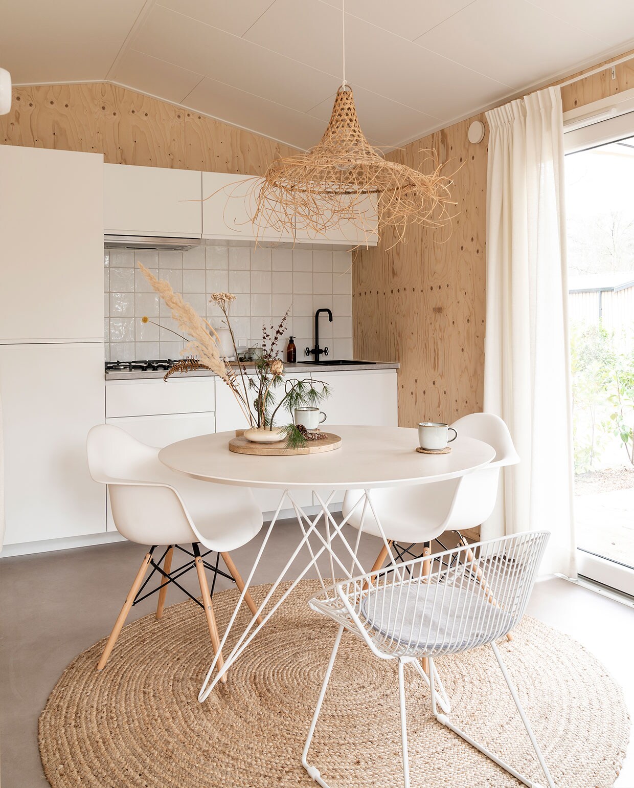 Keuken, kraan Ikea, tegels Schippers tegels. Waterkoker Hema, kop Ikea, zeeppompje herkomst onbekend. Lamp Earthware, tafel Wehkamp, draadstoel, stoelen Vintagelab15, houten plank Xenos. Mokken Ikea, vaas Bloomon, droogbloemen Bloomon en uit het bos, kleed Volero Vloerkleden. vtwonen 11-2021 | Fotografie Muk van Lil | tekst Cathelijne van Wingerden