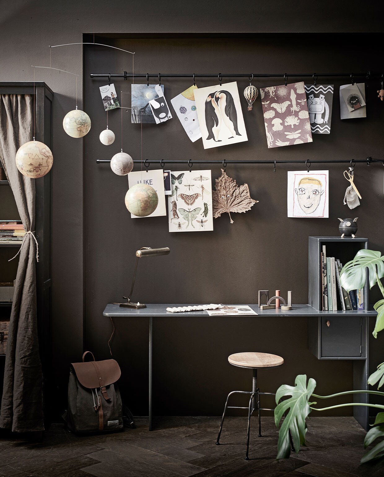 Muurverf Wallpaint LAB eco in kleur Charcoal No. 133 (vestingh.nl). Zwarte gordijnroedeset Bekrafta, 120-210 cm x 19 mm € 9,99, zwarte gordijnringen met klem en haak Syrlig 10 stuks € 2,99 (ikea.nl). Op maat gemaakt kinderbureau, prijs op aanvraag (com-anders.nl). Draaikruk € 79,99 (zarahome.com). Bureaulamp € 125,- (burbri.nl). Canvas hoes met botanical crayons € 40,- (zoenvoorgust.com). Houten blokken Architectural blocks van MinMin € 72,-, piggy bank van Plan Toys € 21,- (gray-label.com). Mobile met wereldbollen € 90,-, luchtballon € 22,- (storeofdaydreams.com). Vloer visgraat eiken bruin geolied uit de vtwonen-collectie € 69,95/m2 (karwei.nl). Overig privébezit. vtwonen 13-2021 kids special | styling Kim van Rossenberg | fotografie Sjoerd Eickmans | Assistentie Sanne van der Beek, Judie Jonker, Kim Suos\n