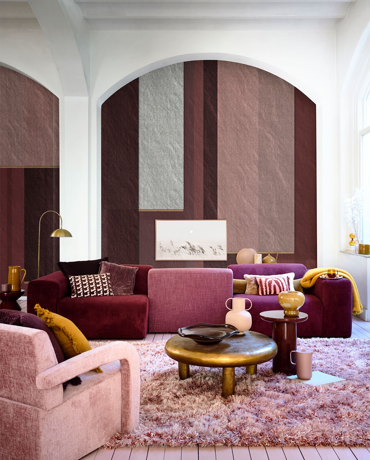 Behang Veli, per m2 € 115,- (wallanddeco.com). Wijnrode en roze bank Oscar, modules vanaf € 375,- (loods5.nl). Fauteuil € 549,-, roze mok € 26,99, roze kan € 29,99, roze bord € 33,49 (jotex.com). Goudkleurige salontafel Thick Disk € 1295,-, glazen schaal € 235,-, bordeauxrode bijzettafel Mob € 475,-, bordeauxrode bijzettafel € 325,- (polspotten.com). Polyester vloerkleed Berino van Linie Design, 230×160 cm € 304,50 messing vloerlamp Jupiter van vtwonen € 166,50 (vtwonen.nl). Auberginekleurig kussen met rafelrand € 54,99, roze vaas met grepen € 29,99, glazen theeglas € 7,99 (sissy-boy.com). Geel kussen met rafelrand € 29,99 (zarahome.com). Gele keramieken kan € 48,50, gele mohair deken € 225,- (paviljoennoord.com). Auberginekleurig kussen € 109,-, kussen met art-decoprint € 49,95, kussen met roze en rode print € 34,95 (loods5.nl/design). Paars fluwelen kussen € 49,90 (brechtjeolsthoorn.nl). Roze vacht kussen € 85,- (homestede.nl). Ronde roze vaas € 59,-, olijfkleurige organische blokkaars € 29,- (festamsterdam.com). Travertine vaas € 89,-, glazen zandloper € 27,90 (letoile.store). Okergele kruikvaas € 47,95 (hkliving.nl). Okergele glazen vaas € 24,99 (hm.com). Overig privébezit. JA | vtwonen 11-2022 | styling Danielle Verheul | fotografie Sjoerd Eickmans