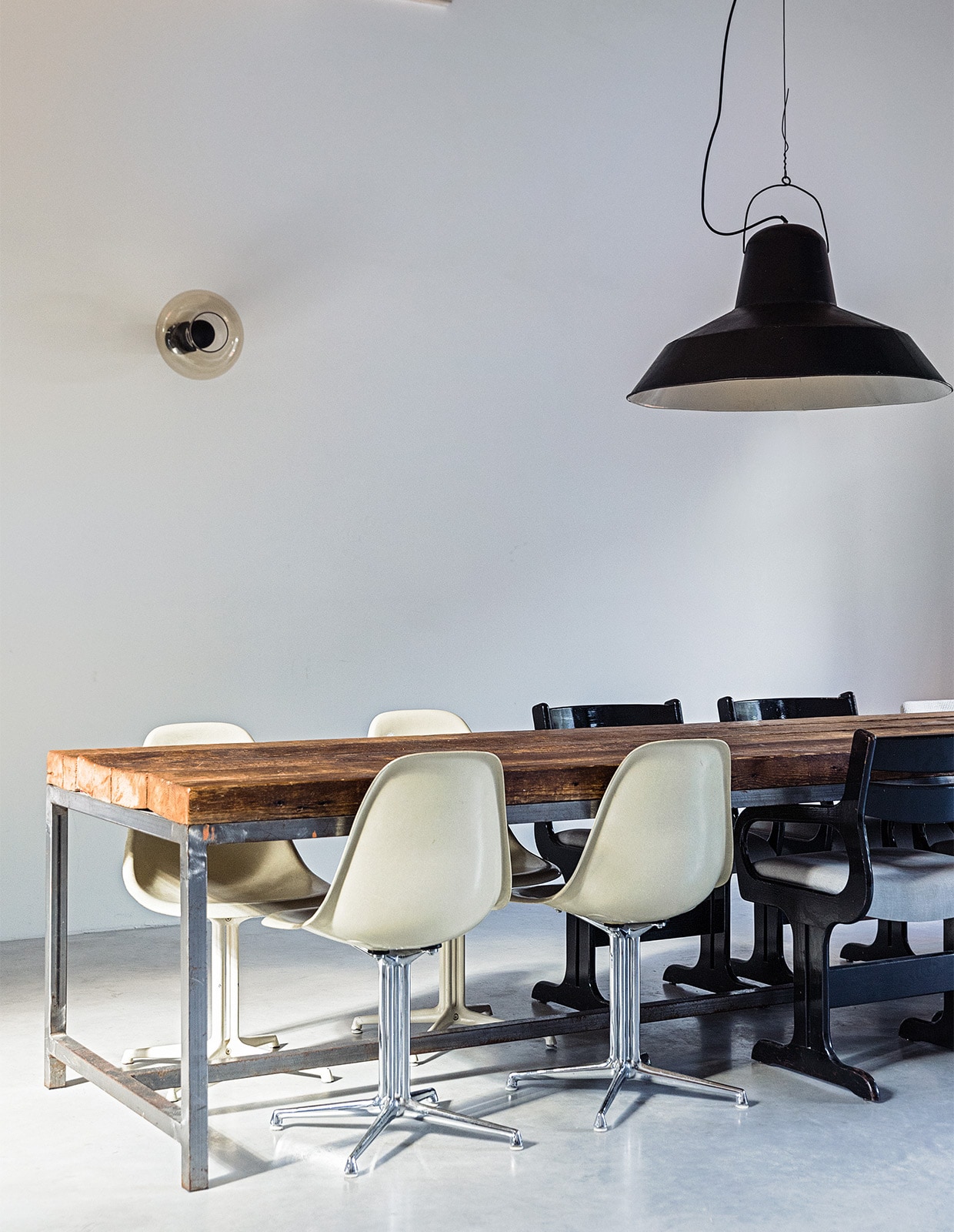 Eettafel, stoelen en lampen vintage. Vloer van gevlinderd beton via Bako Beton. JA | vtwonen 03-2022 | styling Ilona Jongepier  | fotografie Dana van Leeuwen