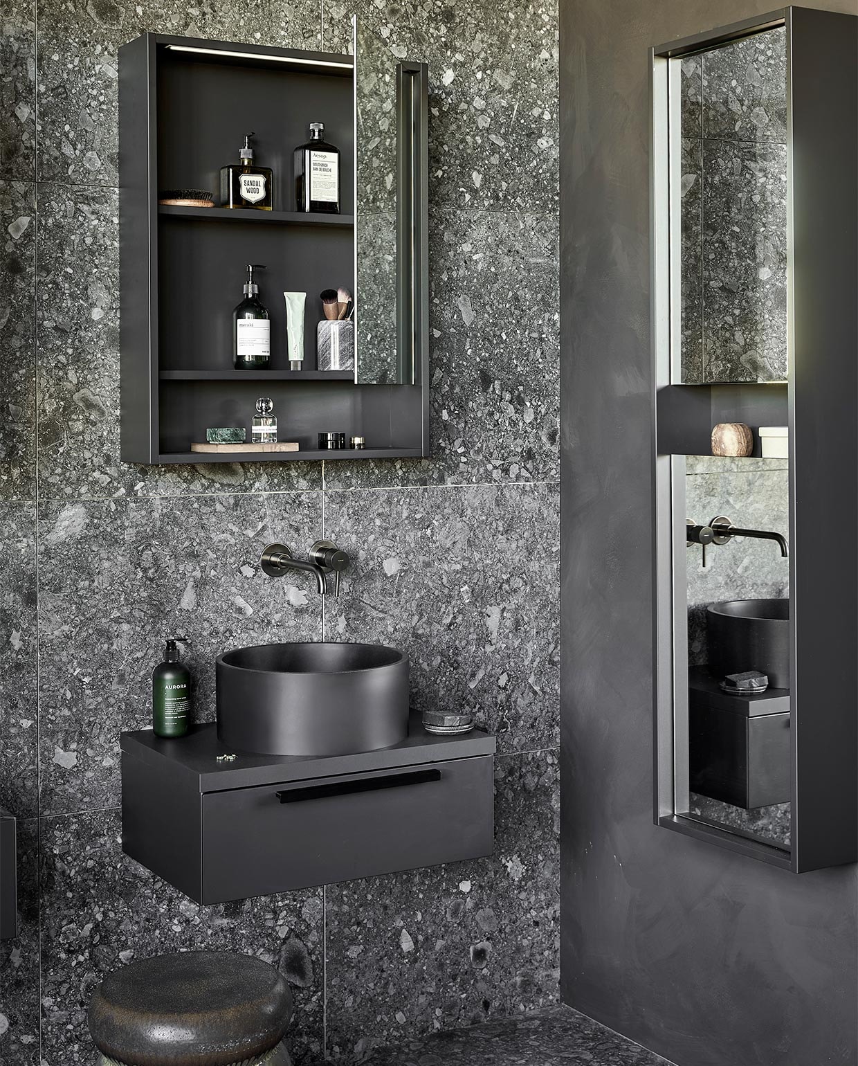 Kunststof spiegelkasten Handy Beauty in zwart, inclusief ledstrip met bewegingssensor, 60x10x80 cm (bxdxh) per stuk € 774,- (ook in breedtematen 90 cm en 120 cm en in wit, zand en grijs). Top solid waskommen Circle in zwart, 37×15 cm (Øxh) per stuk € 488,- (ook in grijs en in Marmer). Kunststof afdekblad in matzwart, 60 cm, per stuk € 145,-. Mat gelakte onderkasten Tidy in matzwart, 1 lade met handgreep, 60x40x20 cm (bxdxh) per stuk € 623,-. Spiegelkolomkast Handy Beauty Long in matzwart met 2 dubbelzijdige spiegeldeuren, 40x16x150 cm (bxdxh) € 762,- (ook in wit, zand en grijs). Top solid bad Endless in zwart, 160x73x57 cm (lxbxh), inhoud 200 liter € 4780,- (ook in grijs en in zand). Op de wand en vloer vtwonen tegels Composite Black Antracite, 60×60 cm, per m² € 65,-. M.m.v. vestingh.nl (kleur op de muur Night Sky No.101), zarahome.com (handdoek, geurkaars in glas), vtwonen.nl (rond juten vloerkleed Eternal van Ferm Living, wandlampen Cast Sconce van Menu, zwart kledingrek Dora van Ferm Living, kruk Bulb van vtwonen), nordal.eu (groen marmeren schaaltje), stories.com (tube crème, oorbellen), wonenmetlef.nl (bruine onderzetter Merge van Ferm Living). Overig privébezit. JA | vtwonen 05-2022 | styling Kim van Rossenberg  | fotografie Peggy Janssen | productie Tanja Saarberg