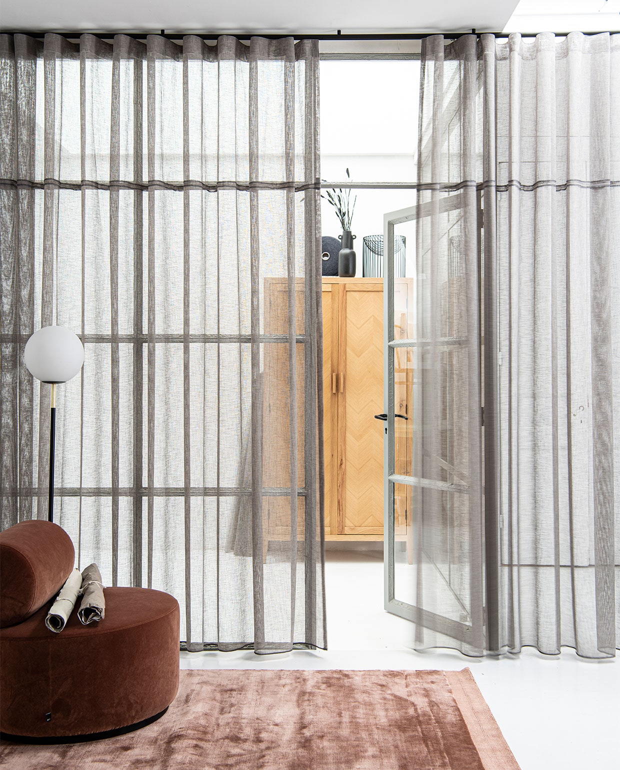 Gerecyclede gordijnstof uit pet-afval in kleur Stro (21), stoflengte 320 cm, per meter € 39,99 (ahouseof­happiness.com). Matzwarte, aluminium roederail 25 mm (Ø) met eindkap Sinus en zwarte plafond­afstandsteun 20 mm, compleet geassembleerd, per meter € 90,- (interstil.nl). Fauteuil Sinclair in Magnolia € 839,- (festamsterdam.com). Vloerkleed Terry in Magnolia, 160×230 cm € 699,- (festamsterdam.com). Vloerlamp Orion met opaal glazen bol € 195,- (zuiver.com). Eiken naturel garderobekast Tulang met visgraateffect, 190x100x50 cm (hxbxd) € 1095,- (loods5.nl). Klos van gerecyclede garens (ahouseofhappiness.com). Zwarte vaas met oren € 30,- (thingsilikethingsilove.com). Metalen schaal van Serax, prijs op aanvraag (dotshop.nl). JA | vtwonen bijlage 03-2022 | styling Marit Saladini | fotografie Louis Lemaire
