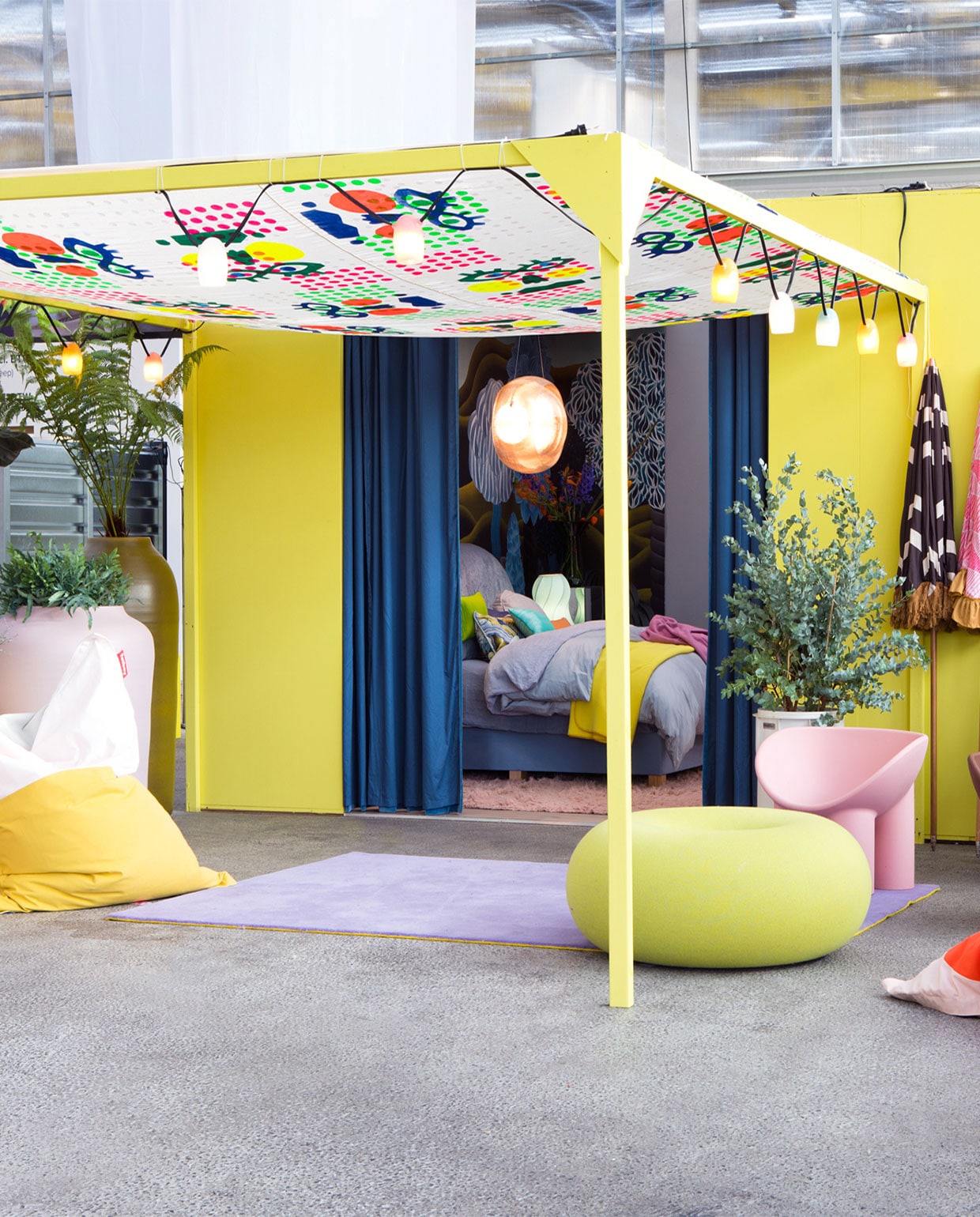 Gele verf buitengevel Googoosh, prijs op aanvraag. IJm Multikleur zonnedoek Banier Big Blush Crazy Colours, prijs op aanvraag. Diedshop Pastelkleurige keramieken potten XXL, prijs op aanvraag Lex Pott. Alle planten en bloemen By Dennis .Tweekleurige katoenen zitzakken Slim Pop € 259,- Fatboy Effen katoenen zitzakken Original Stonewashed € 239,- Fatboy Katoenen strandstoelen € 98,- Weltevree Glazen lichtslinger € 379,- Weltevree Polyester parasols, vanaf € 319,- HKliving Lichtgrijze plantenbak op pootjes, vanaf € 645,- De klein en van Hoff Gekleurd kussen met tekst Love € 49,- Diedshop Kussens met gezichten van ArtCushion, vanaf € 45,- Diedshop Kunststoffen kuipstoelen in roze en bruin Roly Poly, per stuk € 495,- Ted Amsterdam Groengele wollen donut-poef van Sabine Marcelis x Hem € 1799,- Ted Amsterdam Wollen vloerkleden in lila en roze, 170×240 cm, per stuk € 475,- Polspotten Abstracte schilderijen, vanaf € 495,- HKliving Glazen spiegelobject aan de wand, prijs op aanvraag Sodalime vtwonen woonbeurs 2022 | styling Marianne Luning | fotografie Timo Sorber