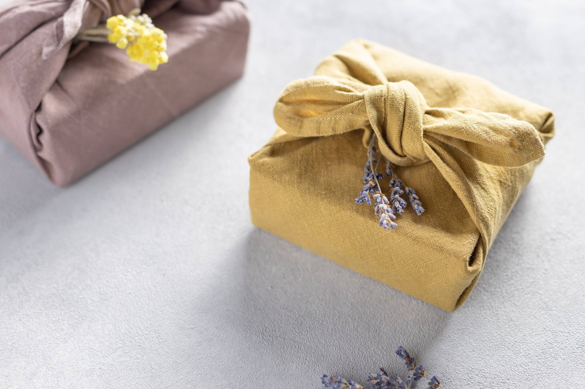 Eco-friendly fabric reusable gift packaging with dried flowers. Furoshiki gifts. Plastic free hand made gift package. close-up. selective focus Getty Images/iStockphoto