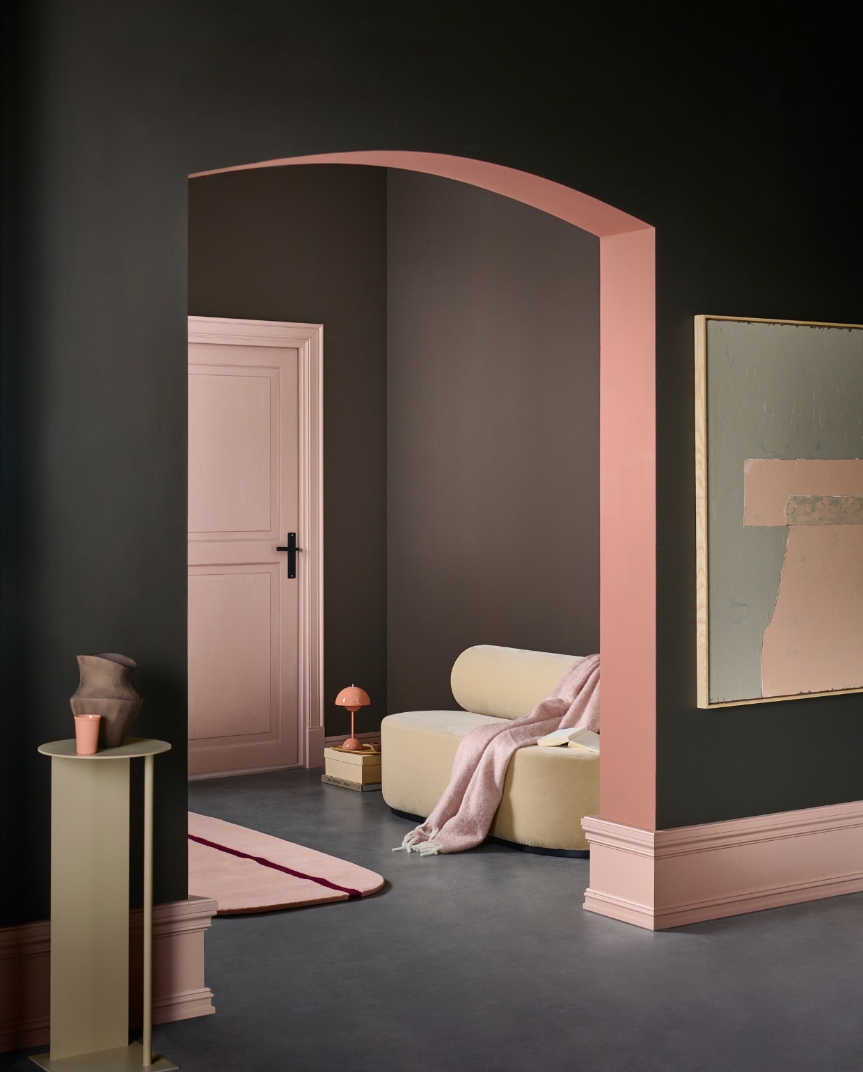 Muurverf deur en plinten Soft Clay, binnenkant boog Blusher, voorste wand Soil, achterwand bij deur en rechtermuur Warm Brown van vtwonen, liter € 23,99, 2,5 liter € 39,99.M.m.v. festamsterdam.nl (bank), hkliving.com (schilderij), vtwonen.nl (vloerkleed van Normann Copenhagen, pilaar van Ferm Living), andtradition.com (tafellamp), zarahome.com (vaas, houten dienblad), dumu.nl (mok), hm.com (plaid). Overig privébezit. vtwonen 1-2023 | Productie Tanja Saarberg | Styling Sanne Ketelaar | Fotografie Sjoerd Eickmans