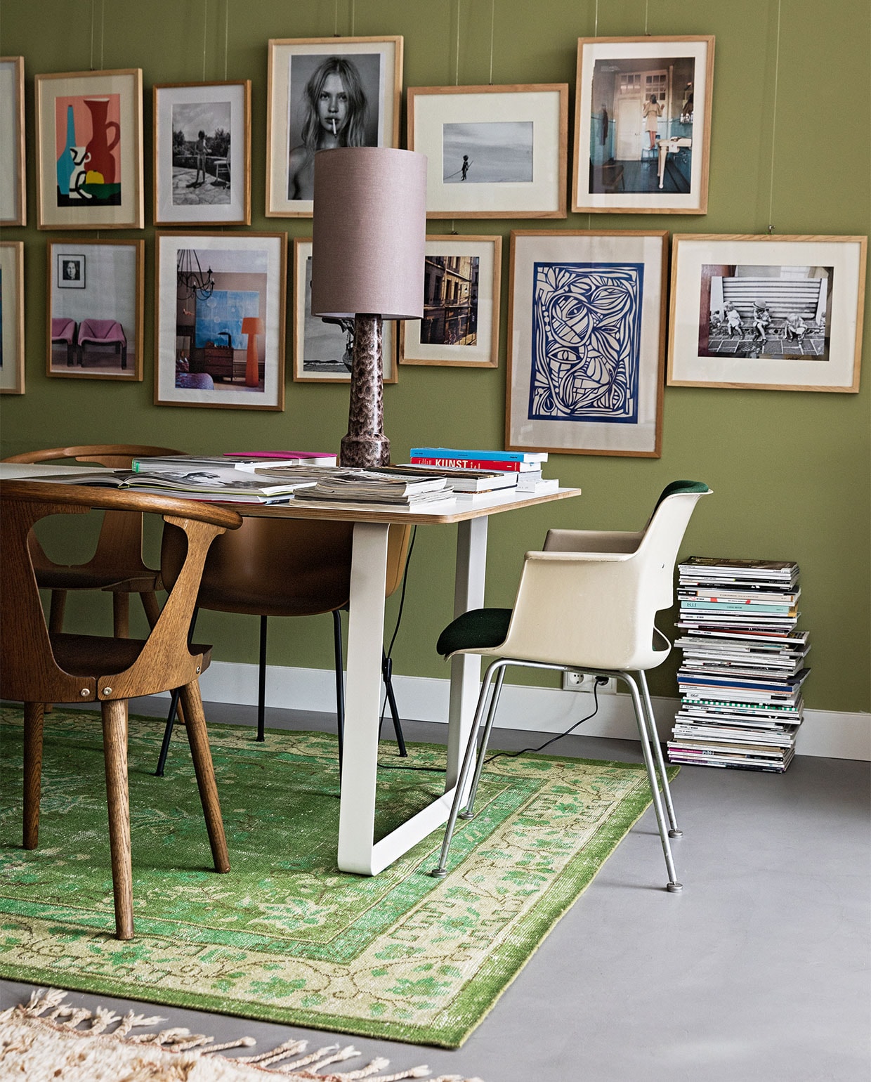 Tafel 70/70 Muuto. Stoelen mix van Fiber Tube Oker en Fiber Wood Dusty Green van Muuto, In Between SK1 Gerookt van &Tradition en vintage Cordemyer van Gispen (groene bekleding) via Best Wel Hip. Schemerlamp en kleed HKliving. Wandverf Boxington van Little Greene. Vloer beton. Kunst eigen verzameling. vtwonen 04-2022 | styling Ilona Jongepier  | fotografie Dana van Leeuwen