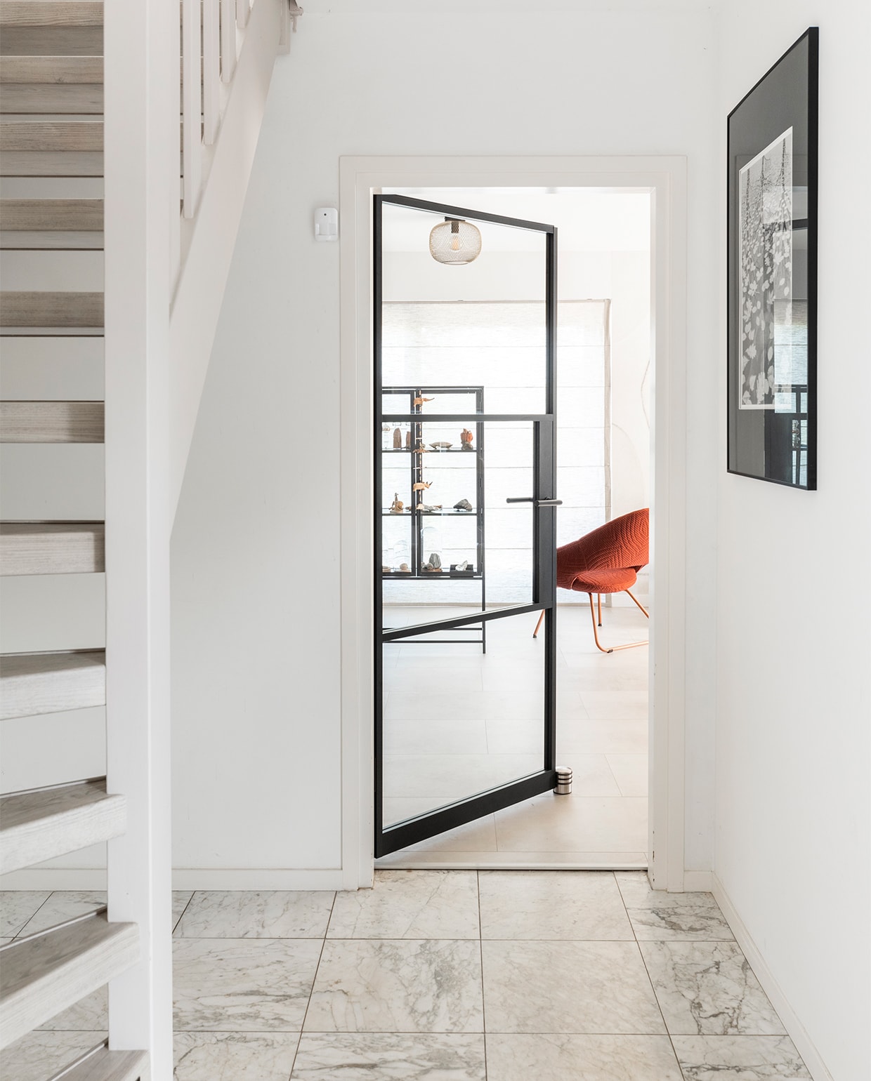 Zwartstalen stompe deur Blaak, prijs op aanvraag (gewoongers.nl). Trap geschilderd in Flexa Creations verf Urban Taupe (flexa.nl). Trap decor Shady Grey, prijs op aanvraag (upstairs.com). Vloer en foto aan de muur privébezit. JA | vtwonen weer verliefd op je huis | seizoen 15, aflevering 5 |  styling Frans Uyterlinde | fotografie Margriet Hoekstra