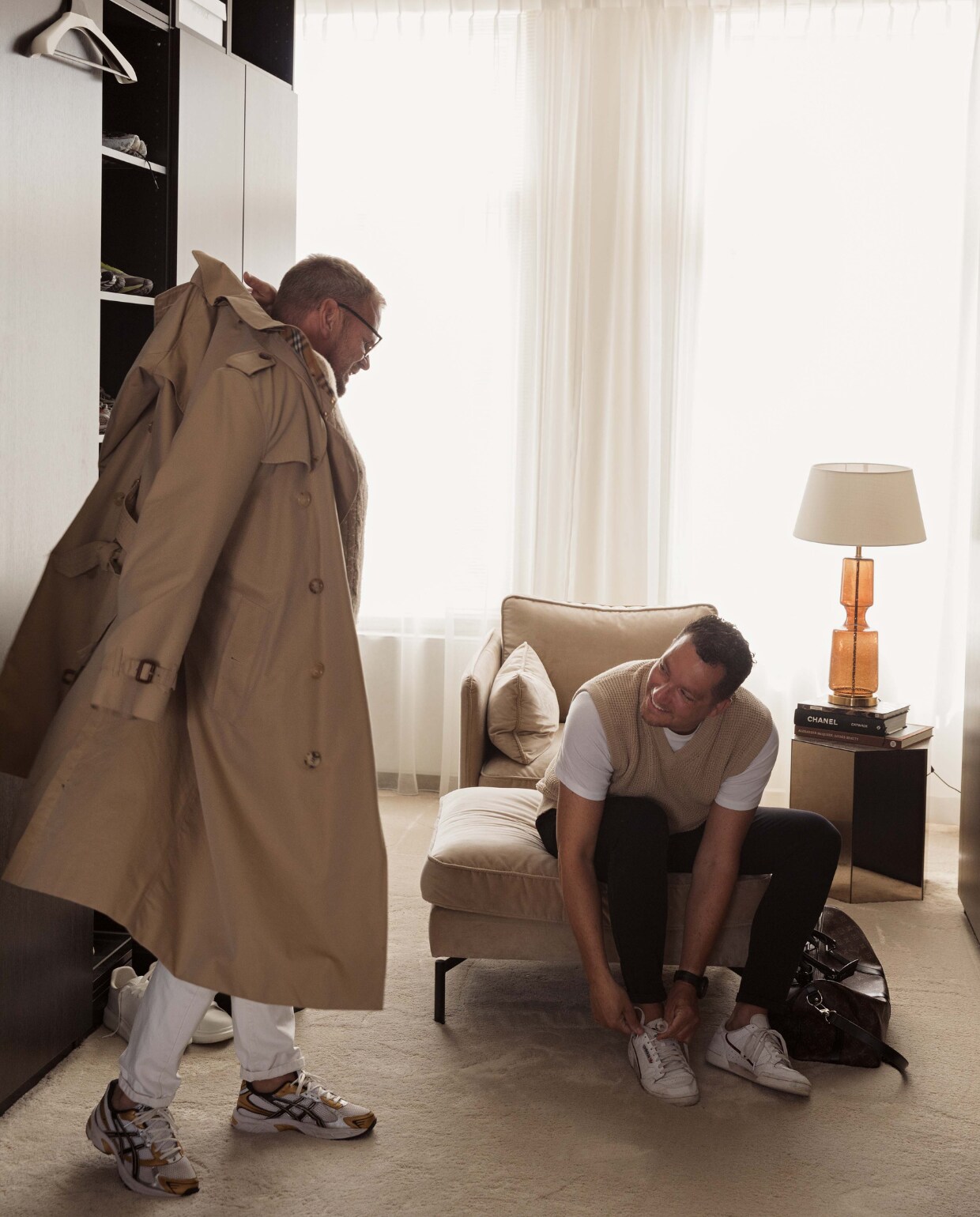 Remco en Stephan in hun herenhuis in Alkmaar. Stoel en poef Pols Potten. Tafel Karwei. Lamp Marktplaats. Kast Ikea. Raambekleding Hema. Jas Burberry. Vloerbedekking Vloerplus. Overig onbekend. vtwonen 11-2022 | styling Ilona Jongepier | fotografie Brenda van Leeuwen