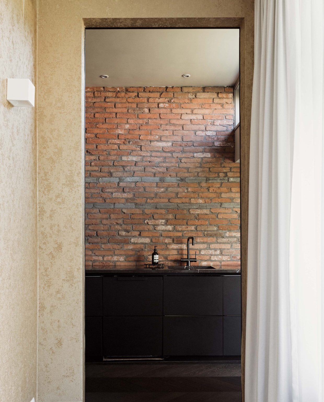 Behang Versace. Wandlamp Rietveld Licht. Steenstrips Trendia. Marmeren keukenblad Pure Natural Stone. Zeephouder Aesop. vtwonen 11-2022 | styling Ilona Jongepier | fotografie Brenda van Leeuwen