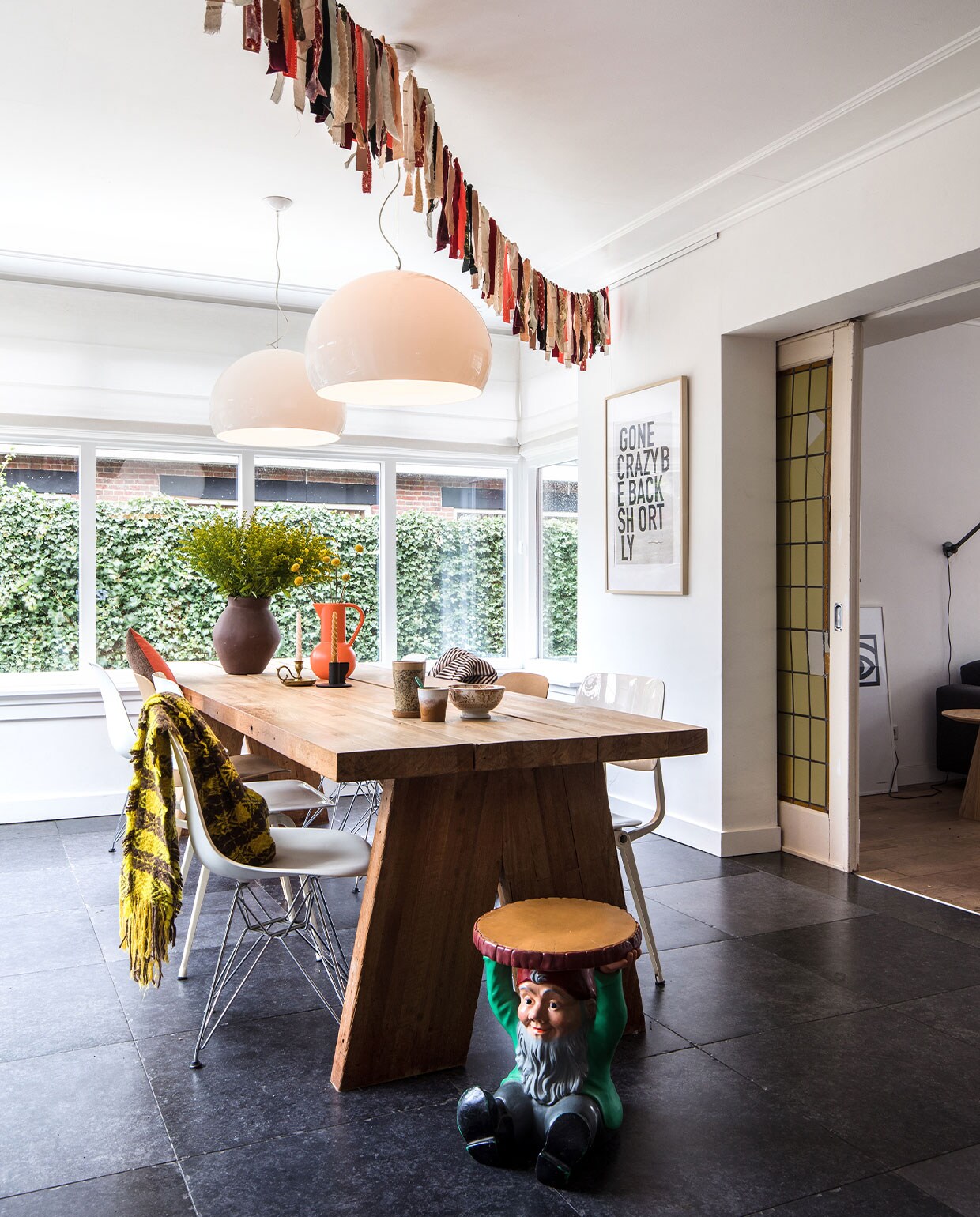 Vloertegels Kronos Ceramiche. Tafel gemaakt door Rob van de houten delen van de oude kegelbanen uit het café van Maaikes vader. Links vooraan stoel Vitra. Links en rechts: Ahrend Revolt-stoelen. Bruine stoelen Odger, Ikea. Hoes met zebraprint Ikea. Plaid herkomst onbekend. Kabouter-bijzettafel Attila en hanglampen FL/Y van Kartell. Vaas Ikea. Kan Raawii. Kaarsen-standaard links geschenk. Kaarsenstandaard rechts Ikea. Thee- en koffiemok HKliving. Kom erfstuk.Vlaggetjes Miranda Maakt. Print My Deer Art Shop. vtwonen 10-2021 | Productie en Fotografie Corine Hoge Bavel | Tekst Marion de Boer