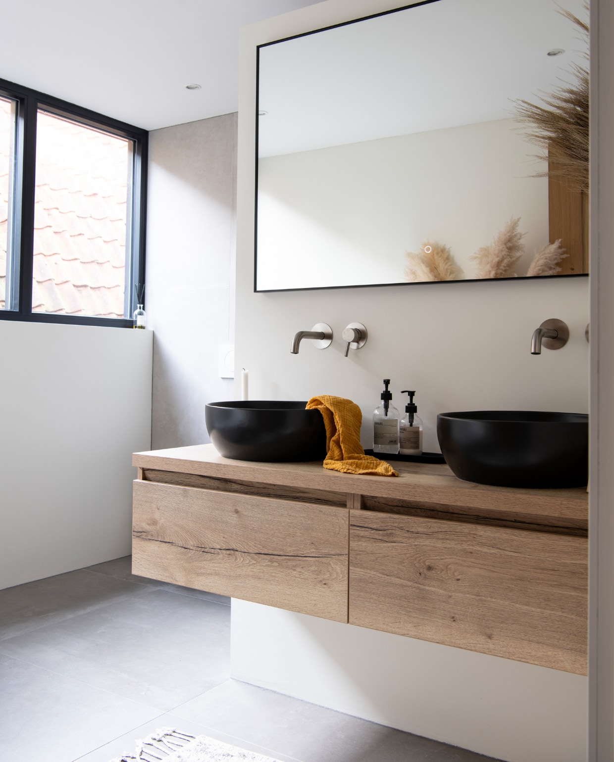Muurverf RAL 9010. Spiegel met ledverlichting onbekend. Kranen Caral van Wiesbaden. Wastafelmeubel Matrix van NewWave. Zeeppompjes Meraki. Kleed HKliving. vtwonen 12-2022 | productie InsideHomePage | styling Studio Marit Saladini | fotografie Louis Lemaire