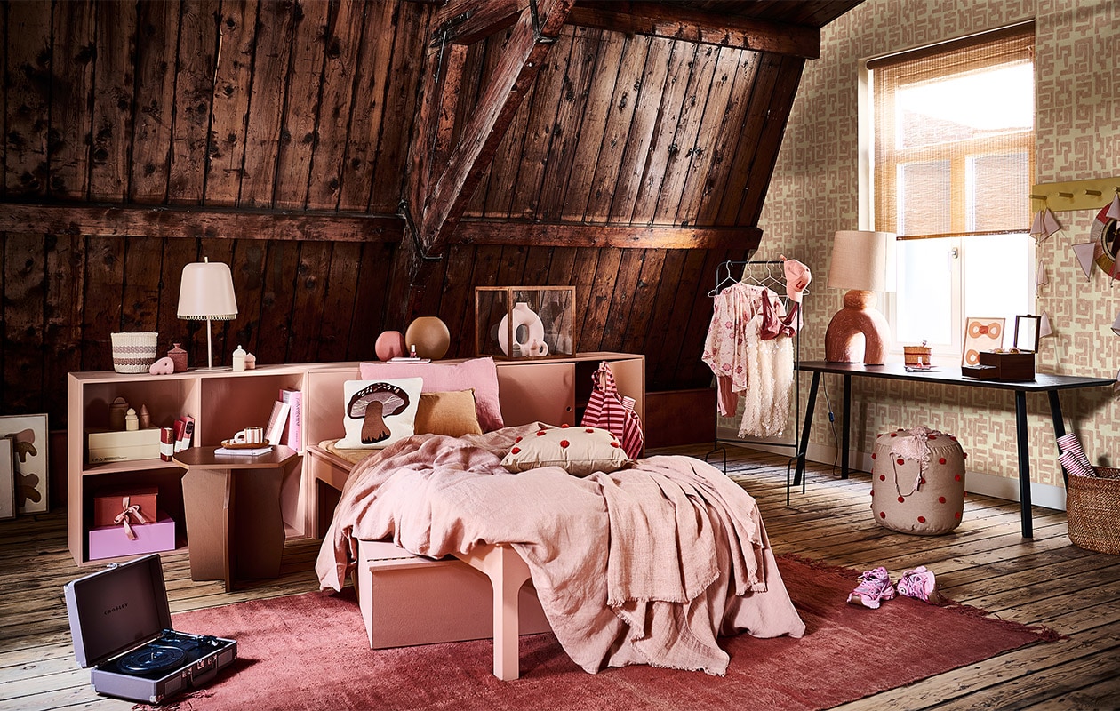 Donkerbruin bureau New Classic Home Desk, 100x60x75 cm (lxbxh) € 1424,-, donkerbruine bijzettafel Scissors Coffee Table 50, 50 cm (Ø) € 429,- (studio-henk.nl). Roze kast, roze bed, gele wandkapstok en roze box onder bed prijs op aanvraag via Combitex (com-anders.nl). Behang TP-329-02 van Élitis, per rol van 70 cm x 10 m € 196,- (loggerewilpower.com). Linnen dekbedovertrek € 350,-, rozerood vintage hennep vloerkleed uit Turkije, 255×177 cm € 990,-, roze linnen kussensloop Lychee € 43,-, gevlochten sisal mand op kast € 32,-, gevlochten mand op de vloer Iringa € 89,-, roze vlaggen aan kapstok Numero 74 € 16,-, roze plaid op bed Margaux Almond € 169,- (couleurlocale.eu). Poef Dot Tufted van Ferm Living € 105,-, houten vitrinekast Miru van Ferm Living € 269,-, kussen Forest Porcini van Ferm Living € 59,-, kussen Dot Tufted van Ferm Living € 59,-, aardewerken potje met geurkaars Ura van Ferm Living € 35,- (vtwonen.nl). Platenspeler Crosley Cruiser DeLuxe in kleur Purple Ash € 90,-, mok en ovaal bord op nachtkastje Milu Snack Set € 45,- (wonenmetlef.nl). Roze nachtlamp op kast € 99,-, roze notitieboeken in kast vanaf € 11,95, pet met print Love € 45,-, blouse met bloemenprint Love Stories € 135,-, zonnebril met bloemenprint in bakje op tafel € 30,-, bh op poef € 70,- (maisonnl.com). Kunstwerk linksonder in hoek, klein kunstwerk linksonder vooraan en kunstwerk in raam prijs op aanvraag (anneoldekalter.com). Sneakers Axel Arigato € 270,-, knalroze doos in kast van Hay € 18,-, kleine roze siervorm links op kast voor mand Hay € 8,-, roze boek op nachtkastje € 17,50 (debijenkorf.nl). Boek in kast Yves Saint Laurent € 69,99, boek Wonderland € 79,99, nagellak op kast en op tafel per stuk € 4,99, make-upkwast op tafel set van 5 € 9,99, ronde vaas in stolp € 29,99, kleine vaas in stolp € 4,99, witte glitterjurk aan rek € 34,99, schotel met bloemvorm op tafel € 7,99, roze broek aan kledingrek € 14,99, bruin potje met rond deksel op gele schoenendoos € 9,99, bh aan rek € 9,99, gestreepte tas € 19,99 (hm.com). Diverse blokken Old City Blocks verdeeld in en op kast € 60,-, zwart metalen kledingrek € 90,-, spiegel aan wandkapstok € 65,- (thearchivestore.com). Rollen rood met wit papier per set van 3 € 7,99, rood gestreept notitieboek op kast € 5,99, box met strik € 14,99 (sissy-boy.com). Bruine ronde vaas € 59,- roze ronde vaas € 32,50,- (festamsterdam.com). Oranje langwerpig kussen € 15,99, bruine houten sieradenbox € 49,99 (zarahome.com). Lamp met oranje voet € 499,- (lanena-home.com). Roze kledinghangers per stuk € 1,33 (sostrenegrene.com). Raambekleding privébezit. JA | vtwonen bijlage 08-2022 | styling Liza Wassenaar | fotografie Sjoerd Eickmans