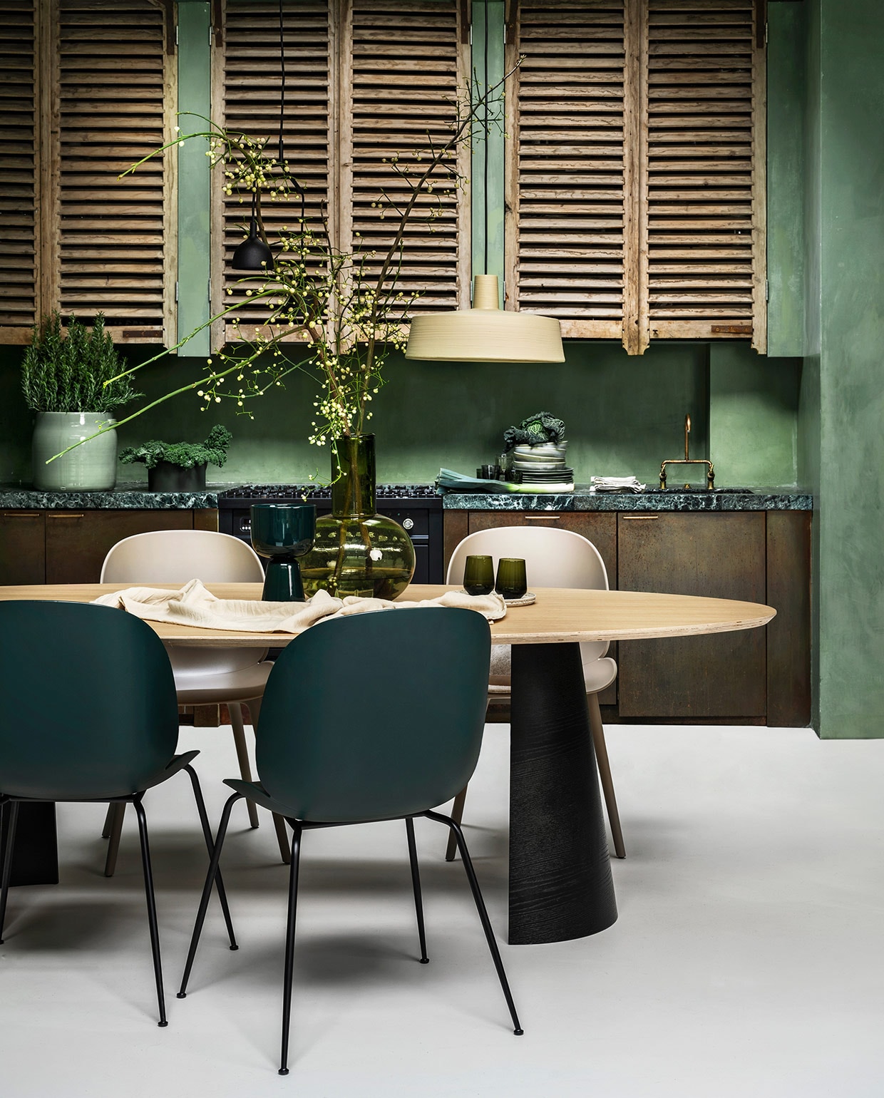 Eikenfineer tafel Arp, 260x120x75 cm (lxbxh) € 2225,-, lichtgroene pot € 83,05 (loods5.nl). Stoelen Beetle en Bat in zand en mosgroen van Gubi vanaf € 349,-, zwarte hanglamp van Menu € 249,-, zandkleurige hanglamp van Marset € 574,-, groene glazen vaas van HKliving € 99,95, linnen tafelkleed van vtwonen € 79,95 (vtwonen.nl). Ingelijste textielkunst Fant € 495,-, keramieken borden en schaal vanaf € 35,- (sukha.nl). Donkergroene aardewerk pot op voet € 69,-, groene waterglazen per 2 € 64,90, donkergroene schaal op aanrecht € 99,- (iittala.com). Borden vanaf € 9,95 (hkliving.nl). Messing keukenfronten prijs op aanvraag. (juliusballer.nl). Marmeren aanrechtblad prijs op aanvraag (janreek.nl). Louvre panelen prijs op aanvraag. (burbri.nl). Koperen kraan prijs op aanvraag (oudebouwmaterialen.nl). Kalkverf Lagune, per liter € 48,- (cartecolori-dialma.nl). Overig privébezit. vtwonen 01-2021 | styling Marianne Luning | fotografie Stan Koolen