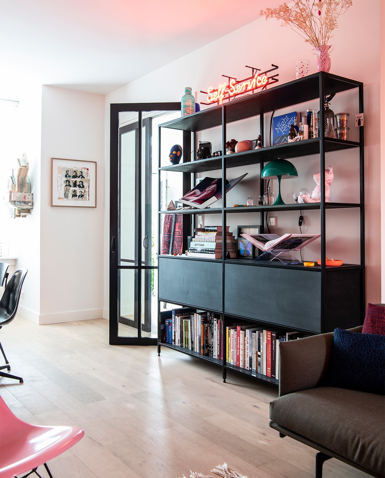Zelfontworpen boekenkast, gebouwd door DeBeer. Neonletters uit kringloopwinkel in Zaandam. Groene vaas en vaas met roze stippen uit glasfabriek Beldi in Marrakesh. Groen lampje Panthella Mini van Verner Panton. Kunstwerken aan de muur Aldo van den Broek. Rest onbekend. NEE | vtwonen binnenkijken special 2021 | productie Insidehomepage | styling Kim Timmerman | fotografie Louis Lemaire