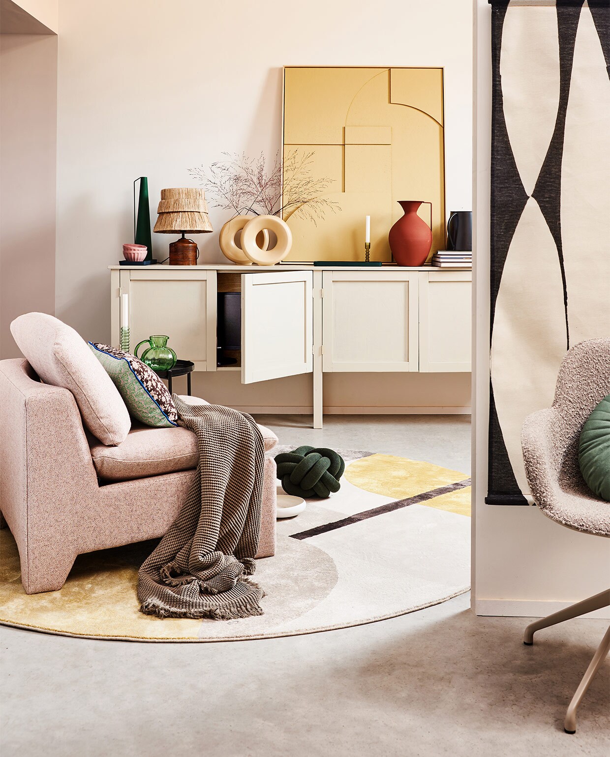 Kast op maat gemaakt, prijs op aanvraag (combitex.nl). Bruin gebloemd kussen by Doris voor HKliving op fauteuil, 35×60 cm € 37,95, boucléstoffen retro loungefauteuil € 949,-, zwart-wit abstracte wandkaart, 97×157 cm (bxh) € 49,95, groene glazen karaf, 16 cm (Ø) € 29,95, okergele en groene glazen kandelaars, per stuk € 17,95, zandkleurig reliëfpaneel ingelijst, 63×83 cm € 469,-, crèmekleurige ronde vazen van HKliving, per stuk € 34,95 (hkliving.nl). Katoenen plaid 130×170 cm € 45,99 (zarahome.com). Vloerkleed Hilton, 240 cm (Ø) € 465,-, taupekleurige armstoel Albert Kuip Swivel € 269,-, tray € 49,- (zuiver.nl). Groen kussen Knot van Design House Stockholm, 30 cm (Ø) € 115,90, zwarte kan van vtwonen € 18,-, bruine vaas van Pols Potten, onderdeel van set van 3 € 220,- (vtwonen.nl). Tafellamp € 119,50 (maisonnl.com). Overig privébezit. JA | vtwonen 02-2022 | styling Esther Jostmeijer  | fotografie Bart Brussee