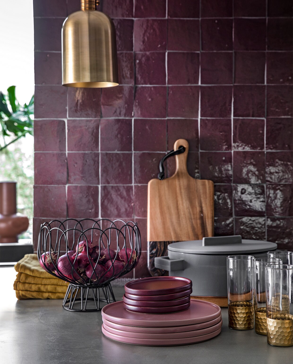 Auberginekleurige zelliges, 10×10 cm per m² € 94,50 (designtegels.nl). Bronskleurig hanglampje Aisha van Lifestyle € 69,95, draadschaal van Present Time € 17,49, grijze ovalen kookpan Terra Cotto van Eva Solo € 77,50, terraroze vaas Theseus van Urban Nature Culture € 59,95 (vtwonen.nl). Plank € 47,95, ovale plank (onder de pan) € 47,95, longdrink glazen Reflexions per stuk € 10,95 (zenzahome.com). Okergele theedoeken per stuk € 3,- (hema.nl). Oudroze dinerborden per stuk € 9,99, aubergine kleurige bordjes per stuk € 4,99 (hm.com). JA | vtwonen 02-2019 | styling Moniek Visser  | fotografie Peggy Janssen