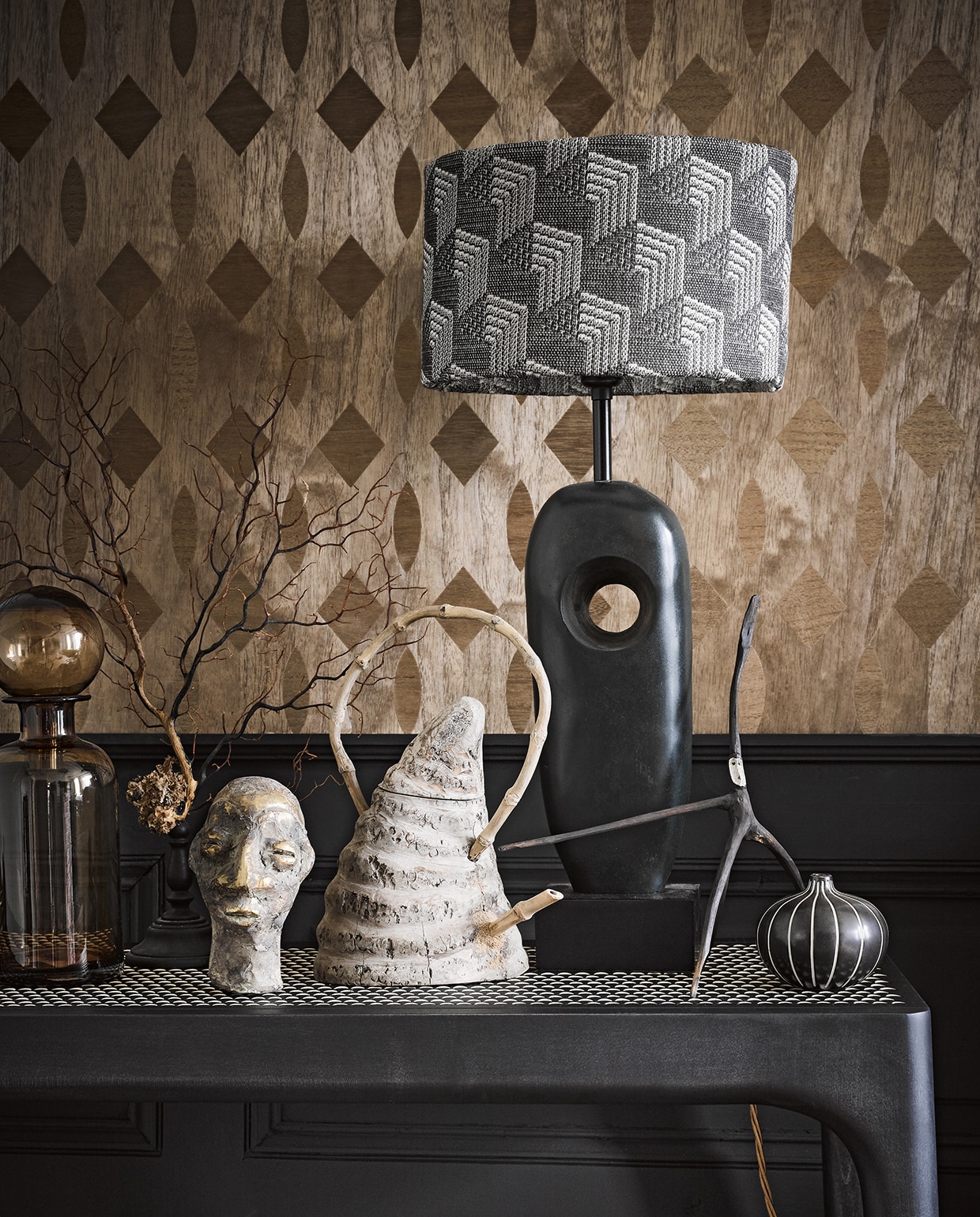 Fineerbehang RM 43572 90×100 cm € 259,- (elitis.fr). Lambrisering zwart geschilderd met verf in kleur Jack Black van Little Greene, per liter € 45,- (deruamsterdam.nl). Lampenkap van Nobilis-stof, per meter € 189,-, bronzen lampvoet € 648 (wva.nl). Apothekerspot € 39,- (loods5.nl). Gieter € 135,- (esatto.nl). Aap-takje € 65,- (brechtmurreatelier.nl). Zwart-wit bolvaasje € 19,95 (maisonnl.com). Tafel met geperforeerd blad € 1.537,- (homestede.nl). Overige privébezit. vtwonen styling 03-2020 | styling Liza Wassenaar | fotografie Alexander van Berge