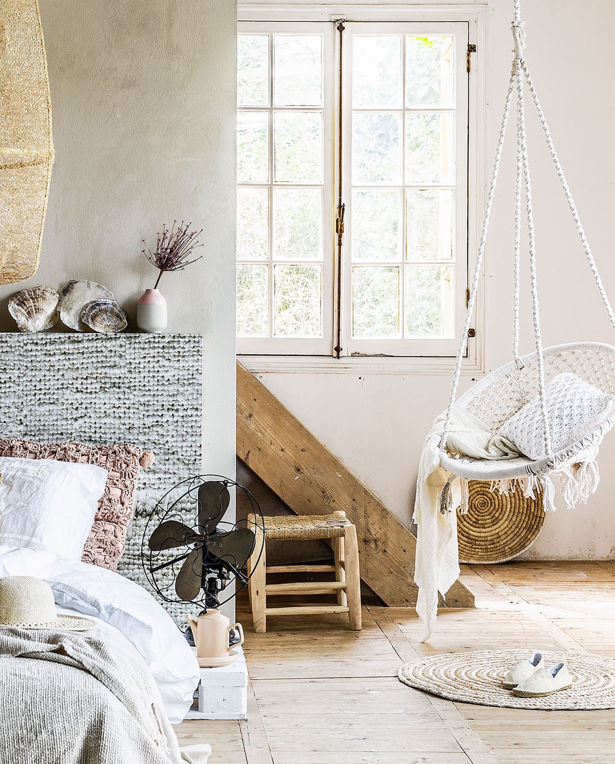Bed gemaakt van vier houten pallets, elk 80×120 cm (wit geverfd), daarop twee keer matras Morgedal, 80×200 cm € 139,- (Ikea). Hoofdbord behangen met vliesbehang uit de vtwonen collectie 53×333 cm per rol € 99,- (www.vtwonen.nl). Wit linnen dekbedovertrek, 240×220 cm € 79,99, naturel raffia kussen € 19,99, gebreide katoenen deken € 39,99 (H&amp;M Home). Gehaakt roze kussen € 54,95 (The Go’Round). Dun linnen gordijn per meter € 20,- (Boerenbonthal). bamboestok € 3,95, schelpen € 4,95 (Intratuin). Vaasje in roze-grijs van House Doctor € 11,95 (www.vtwonen.nl). Hanglamp Z2 Tea Dyed, 77 cm € 629,- (Ay Illuminate). Oude ventilator (vergelijkbare bij Vivre Interieur Authentique). Theepot Blush € 18,50, ontbijtbord Blush € 9,95 (Present Time). Kruk met sisal zitting € 38,- (Teranga). Ronde mat van Madam Stoltz € 61,95 (www.vtwonen.nl). Witte macramé hangstoel € 49,95 (Loods 5). Gehaakt kussen 40×40 cm € 24,95 (Mrs. Bloom). Schaal uit Bangladesh van Return to Sender € 15,- (Hema). Wand geverfd in kalkverf, kleur Calce per liter € 41,25 (Carte Colori). Linnen sjaal (Zara). Espadrilles (Intratuin). Zonnehoed (H&amp;M Home). vtwonen 07-2015 | styling Moniek Visser  | fotografie Sjoerd Eickmans