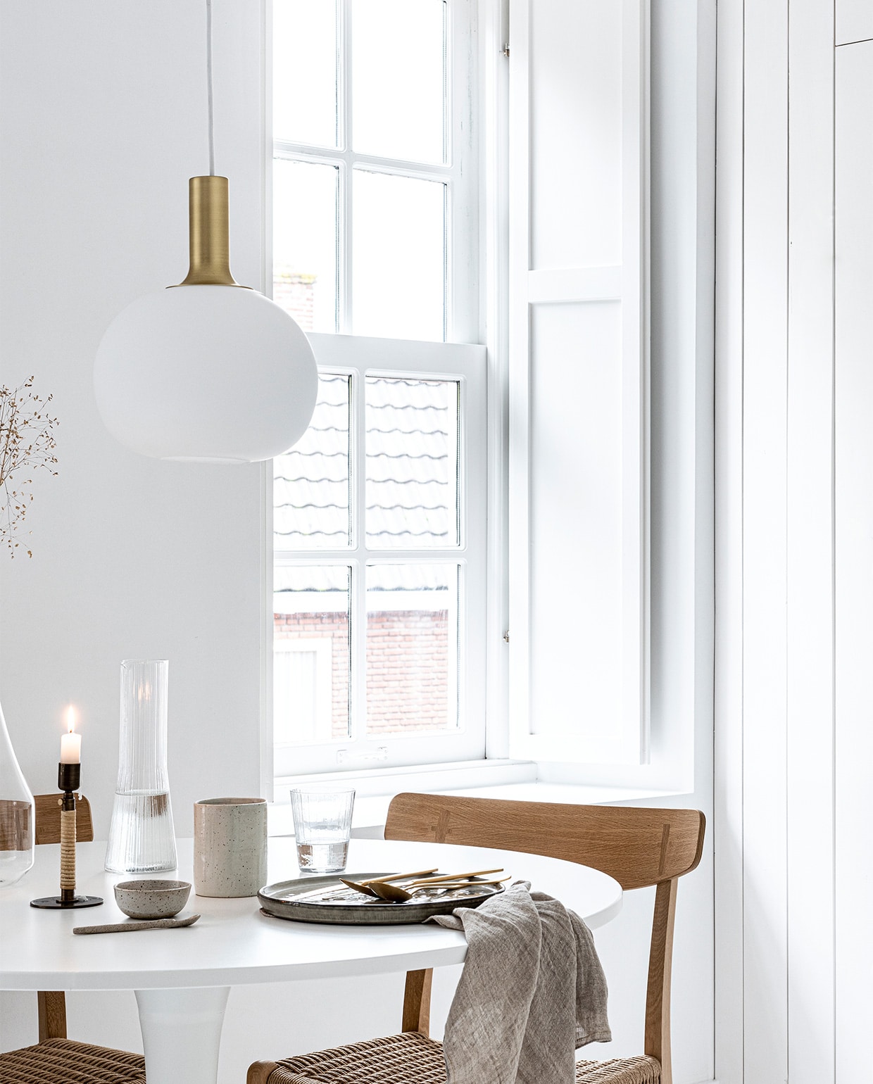 Art print van Gurilla, 50×70 cm € 79,-, eikenhouten frame, 50×70 cm € 69,- (theposterclub.com). Hanglamp Alton 25 van Nordlux € 69,95, groen dinerbord uit de Artisan collectie van Salt &amp; Pepper, Ø 26,5 cm € 9,95, gouden bestek van Amefa, 24-delig € 57,95, theedoek uit de vtwonen collectie, 60×60 cm € 12,95 (vtwonen.nl). Witte ronde eettafel Docksta € 149,- (ikea.nl). Eikenhouten eetkamerstoel met gevlochten zitting CH23 van Carl Hansen &amp; Søn € 860,- (coosdewitwonen.nl). Messing kandelaar omwikkeld met rotan Duca € 69,- (menu.as). Glazen karaf met handvat € 22,99, drinkglas met ribbels € 2,99, kegelvormige glazen kan met ribbels € 12,99, beker aardewerk € 9,99 (zarahome.com). Overig privébezit. vtwonen 13-2019 | styling Kim van Rossenberg  | fotografie Sjoerd Eickmans