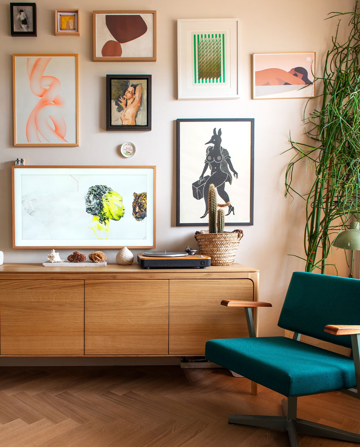 Bureaustoel Galvanitas, dressoir Sav &amp; Økse. Platenspeler House of Marley. Plantenpot Dekatuin. Lamp vintage. Kunst: Krin Rinsema (linksboven), werk ernaast cadeau gekregen, Balance van My Deer Artshop (midden boven), Sigrid Calon (groen rechtsboven), Quintin Monge (liggende vrouw rechtsboven), Rutger Paulusse (oranje links midden), vrouw in midden cadeau gekregen, Piet Parra (zwart mens-dier), Marije Tolman (roze vogel). Onderaan tv The Frame van Samsung met als beeld een kunstwerk van Ruby Onyinyechi Amanze. vtwonen 13-2021 kids special | productie De Binnenkijkers | styling Jeske Weel | fotografie Caroline Coehorst | tekst Chris Muyres