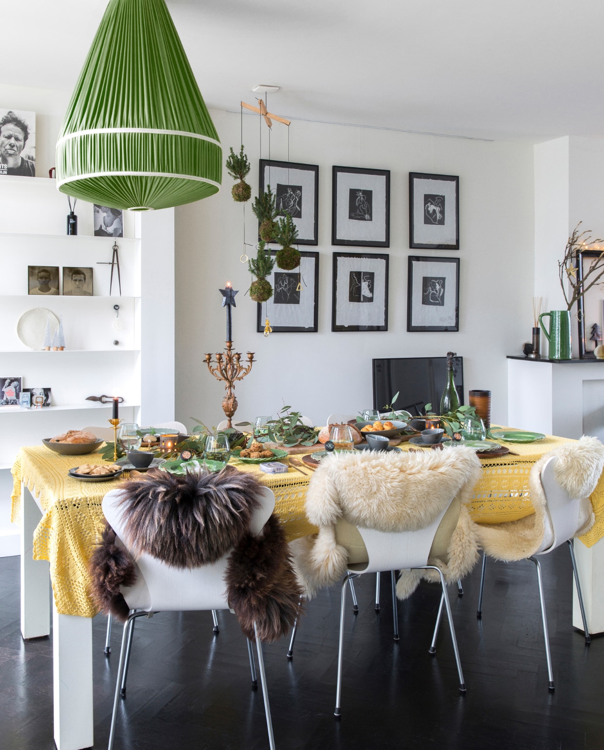 Eettafel maatwerk Woodies at Berlin, tafelkleed rommelmarkt, vlinderstoelen Fritz Hansen, vachten Ikea en markt. Servies, glaswerk, bestek, kaars met ster, groene keramieken kan K’ook!, grote kandelaar familiestuk, kleine kandelaar Goed in Stijl, groene takken Floribundus. Mobile met kokedama’s BoulevardB, hanglamp IJ-Hallen. Zwarte lijsten ’t Kwassie, kunst Frenk van Heeswijk. Op de wandplanken van boven naar beneden en v.l.n.r. boek Waits van Anton Corbijn, foto Brigitte Bardot Goed in Stijl, geurstokjes Frau Tonis Parfum (ook op de schoorsteenmantel), portretfoto’s zoons gemaakt door Sevilay Maria, passer Huibs opa. Visgraatvloer Van Dijk & Ko, zwart geschilderd en gelakt Sigma, muurverf RAL 9010. Overig onbekend. vtwonen 13-2022 | styling Barbara Natzijl | fotografie Margriet Hoekstra | tekst Sunna Borghuis