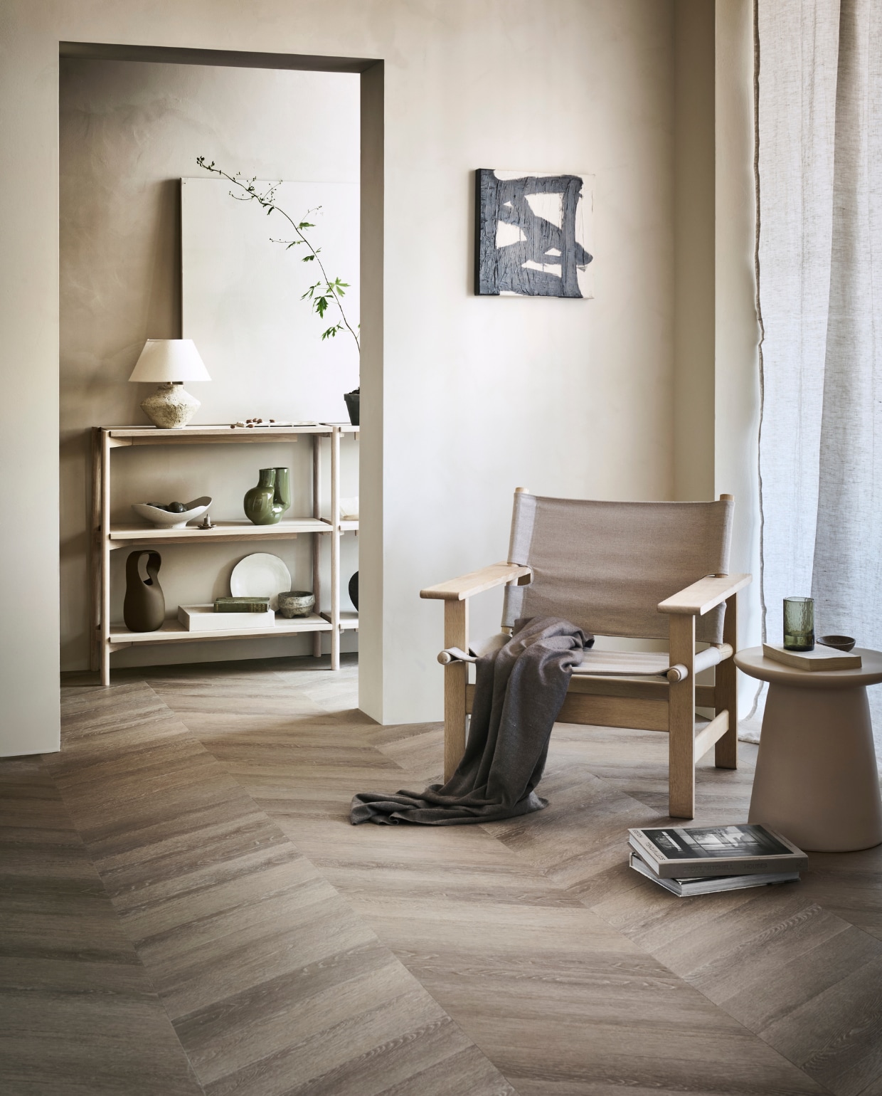 pvc-vloer Noble, kleur Sun Kissed, 53,8×11,7 cm, dryback per m² € 48,95 (alleen verkrijgbaar als dryback).M.m.v. pure-original.nl (muurverf Fresco in kleur Old Linnen en Canvas), designtales.nl (fauteuil), vtwonen.nl (houten sidetable van Vestbjerg, groene vaas van Hay, bruine vaas van Bloomingville, keramieken kruk van HKliving), instagram.com/ansdekruyf (schilderij), arket.com (grijze schaal, dienblad van aardewerk), zarahome.com (gordijn, tafellamp, bord, linnen doos, groen glas, stenen schaaltje). Overig privébezit. vtwonen 10-2022 | productie Tanja Saarberg  | styling Sanne Ketelaar | fotografie Sjoerd Eickmans