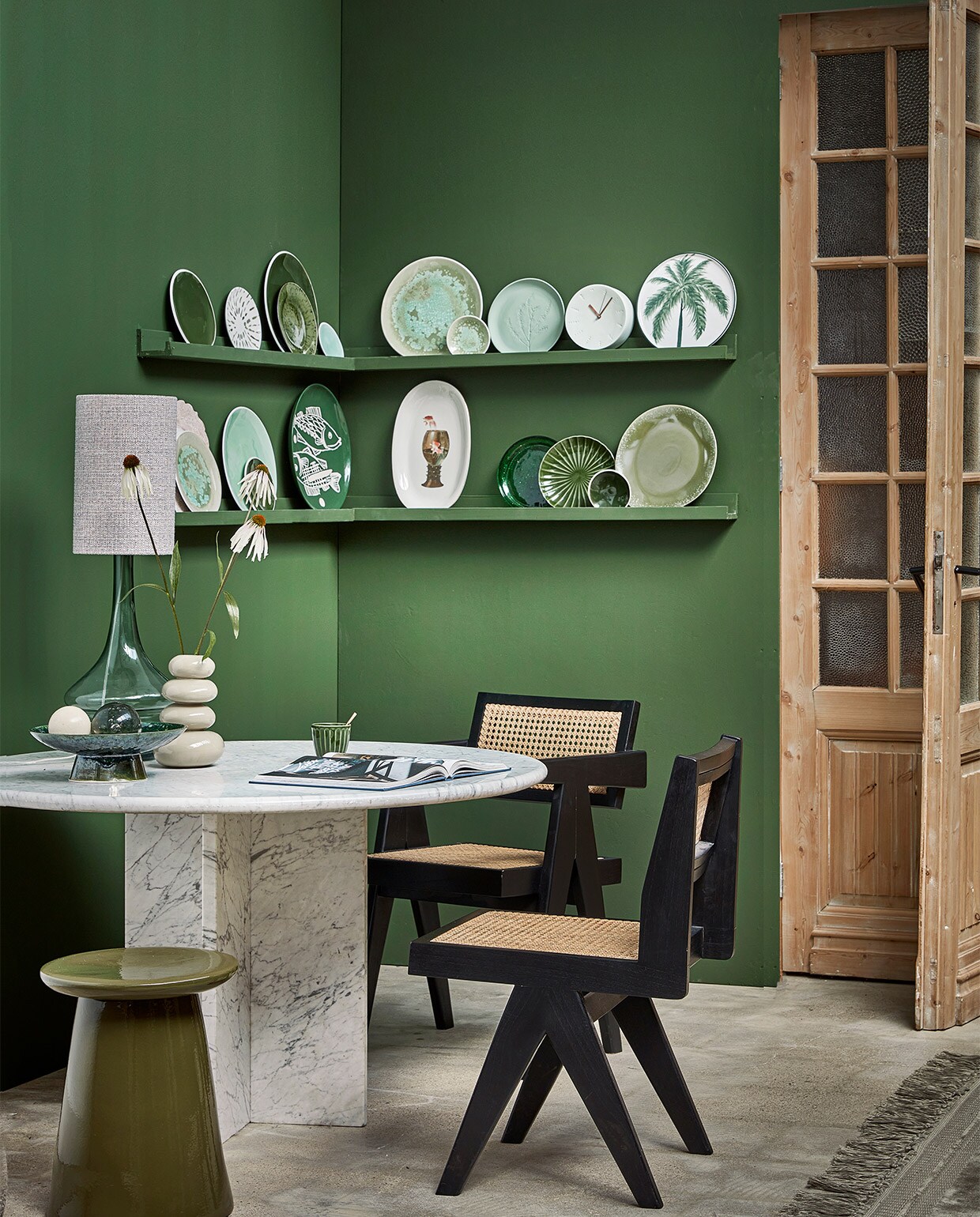 Op de muur extra matte verf Flexa Pure Colorlab 2018 Full Jade, 1 liter € 33,99 (flexa-pure.nl). Houten deuren prijs op aanvraag (empire-bv.nl). Eettafel van Carrara-marmer € 2150,-, Pierre Jeanneret-stijl eetkamerstoel vanaf € 475,- (cocooncollectables.nl). Lampenvoet Straw, 22 cm (Ø) € 119,-, lampenkap Chunky, 20×32 cm (Øxh) € 49,95, keramieken kruk Button van vtwonen, 35×45 cm (Øxh) € 129,- (basiclabel.nl). Fruitschaal The Emeralds € 79,95, mok The Emeralds, set van 4 € 24,95 (hkliving.nl). Vaas Pebbles € 49,99 (urbannatureculture.com). Vloerkleed Ravel, 170×240 cm € 329,- (bepurehome.com). Fotoplank Avnede, 115×7 cm € 10,- (jysk.nl). Borden bovenste rij: groene borden met witte rand Green 091 klein € 35,- en groot € 49,-, klein turquoise bord Green 233 € 14,-, turquoise bord met verweerd glazuur Green 021 groot € 35,- en klein € 14,-, bord met plantenreliëf Green 05 € 30,-, porseleinen klok € 85,- (harmenelke.nl). Wit gebaksbord met groene vlekken Arts &amp; Craft Sparks € 12,95 (urbannatureculture.com). Groen geglazuurd bord The Emeralds, set van 2 € 24,95, bord met palmboom € 11,95 (hkliving.nl). Onderste rij: turquoise bord met verweerd glazuur Green 021 € 35,-, groot turquoise bord Green 233 € 49,-, groen bord Green 091 € 14,- groen bord Green 062 € 14,- (harmenelke.nl). Wit brocante bord € 84,- (ingridwens.nl). Bord met vis Arts &amp; Craft Fishes € 49,95 (urbannatureculture.com). Witte serveerschaal met bokaal € 85,- (lylies.nl). Groen geglazuurd bord The Emeralds, € 6,95, groen bord met reliëf The Emeralds, set van 2 € 22,95, dinerbord 70’s, set van 2 € 27,95 (hkliving.nl). vtwonen 10-2022 | styling Kim Timmerman | fotografie Peggy Janssen