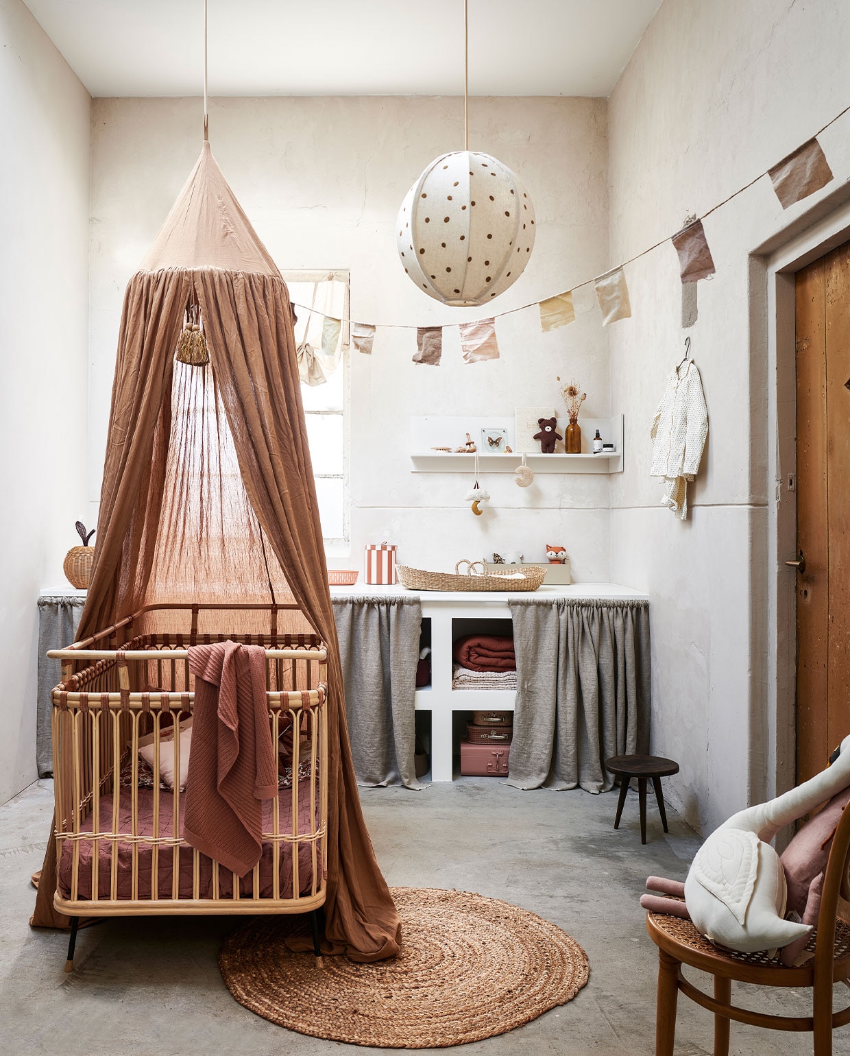 Bed Children’s bed Frederick van Bermbach Handcrafted € 885,-, deken Diamond Deep Clay van Camomile London € 45,-, gebloemde plaid Antoinette Cream Bohemian Flowers van Louise Misha € 89,-, donkerbruine knuffelbeer Bernard van Bonton € 24,-, knuffel vos Renard Tissu van Bonton € 22,-, metalen ovale opbergmand in kleur Roest van Hay € 49,-, ronde gestreepte opbergmand van Oyoy Living Design, set van 3 € 60,-, muziekmobile Moon &amp; Star van Konges Sløjd € 47,-, beige metalen opbergbox van Ferm Living € 65,-, houten borstel in vorm van schelp van Konges Sløjd, set van 3 € 40,-, bedhemel in kleur Almond van Konges Sløjd € 100,-, gevlochten opbergmand appelvorm van Ferm Living € 45,-, roze koffer van Bonton € 29,-, set koffertjes met print van Oyoy Living Design € 24,90, knuffel paard in Dusty Rose van Ferm Living € 55,- , witte pyjama Dot van Studio Feder € 60,-, gebreid roze dekentje Akira Brick van Hvid € 90,-, dekens in de kast: lichtroze Mellow Tawny Blanket van Garbo &amp; Friends vanaf € 55,-, Cinnamon Muslin Filled Quilt van Garbo &amp; Friends € 120,- (storeofdaydreams.com). Lichtbeige rolgordijn € 19,99 (hm.com). Hanglamp Dots Textile van Ferm Living € 155,- (coulourlocale.eu). Rond juten vloerkleed 100 cm (Ø) € 46,- (vtwonen.nl). Verschoonmand zeegras van Cam Cam € 69,95, knuffel zwaan Vicky Swan van Numero 74 € 64,- (lidor.nl). Speendoekje in de vorm van maan van Dappermaentje € 23,95 (psikhouvanjou.nl). Babyverzorging van Alma vanaf € 35,-, houten rammelaar € 22,95, babybook € 49,95 (zoenvoorgust.com). Siliconen badthermometer muis € 17,99, beige kam met schildpadmotief € 11,99 (zarahome.com). Gordijnen voor de kast zelfgemaakt van linnen effen stof € 22,50 per strekkende meter (kniphal.nl). Fopspeen kers € 4,50 (dekleineparade.com). Wandplank zelfgemaakt. Overig privébezit. JA | vtwonen 13-2021 kids special | styling Kim van Rossenberg | fotografie Sjoerd Eickmans | Assistentie Sanne van der Beek, Judie Jonker, Kim Suos\n