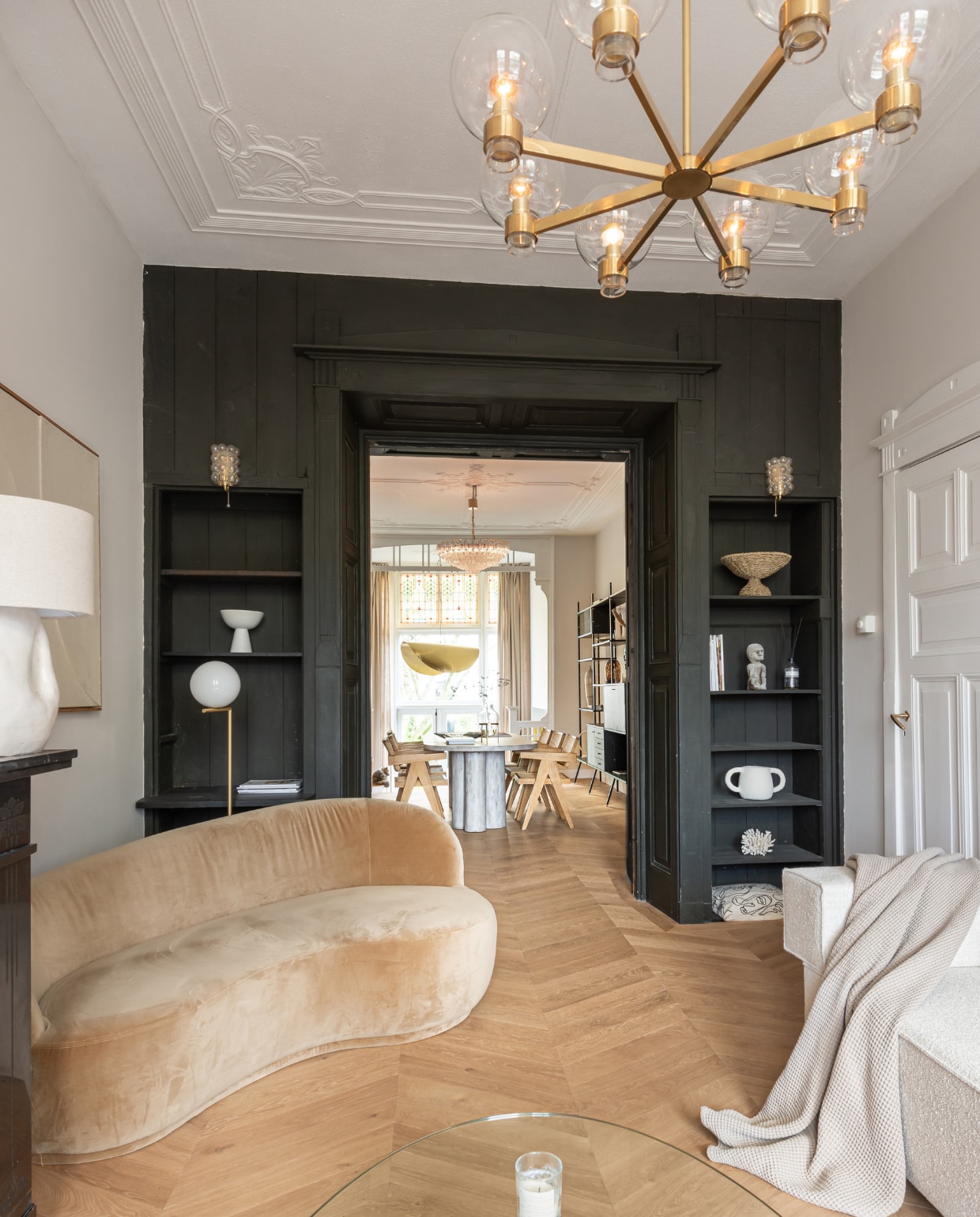 Fluwelen bank Sofa Company, staande lamp Flos, bank Flow Rotterdam, hanglamp Venini, lamp op schouw van Margreet van Schaijck, accessoires in kast van Maison Jolie, vintage en souvenirs, eettafel op maat gemaakt, eetkamerstoelen Aime Té Studio messing hanglamp Gervasoni. Overig onbekend. vtwonen 11-2022 | productie Living Inside | fotografie Peter Dekens