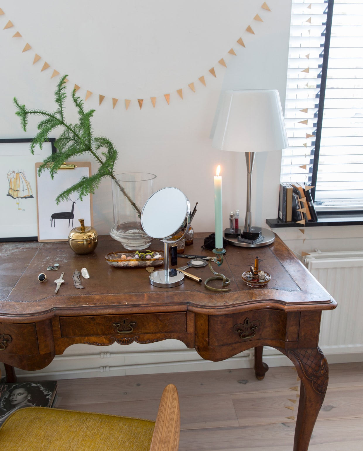 Antieke tafel cadeau gekregen, schemerlamp Ikea, spiegel op voet drogist, kandelaar en sieradenbakje rommelmarkt, tak Floribundus. Stoel 366 Concept. Witte beits vurenhouten vloer Sigma, muurverf RAL 9010. Overig onbekend. vtwonen 13-2022 | styling Barbara Natzijl | fotografie Margriet Hoekstra | tekst Sunna Borghuis