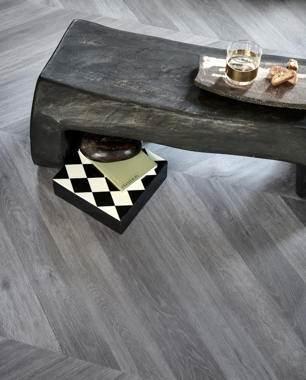 Novilon vloer Koffie, per m² € 35,65.M.m.v. interiorcowboys.com (salontafel, keramieken dienblad), vtwonen.nl (glas met messing van Serax), hm.com (doos met ruitpatroon), zarahome.com (groen boekje). Overig privébezit. vtwonen 13-2022 | productie Tanja Saarberg | styling Sanne Ketelaar | fotografie Sjoerd Eickmans