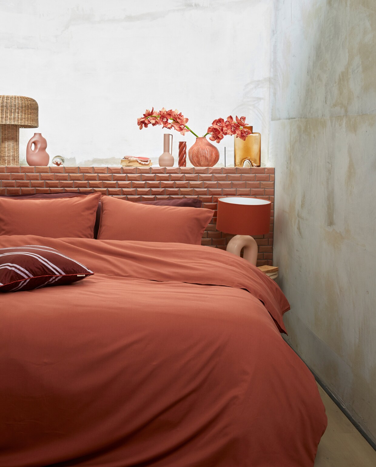 Katoensatijnen dekbedovertrek Earth, 140×200/220 cm € 89,95, 200×200/220 cm € 169,95, 240×200/220 cm € 179,95, fluwelen kussen met bies Diagonal, 50×50 cm € 39,95. M.m.v. nordal.eu (rieten tafellamp Atum), sissy-boy.com (presse-papier, oogmasker, terra gevlochten vaas), loods5.nl/design (gedraaide kandelaar), polspotten.com (roze metalen vaas Roman), mimiettoi.com (glazen vaas). Overig privébezit. vtwonen 13-2022 | productie Tanja Saarberg | styling Danielle Verheul | fotografie Richard Smit