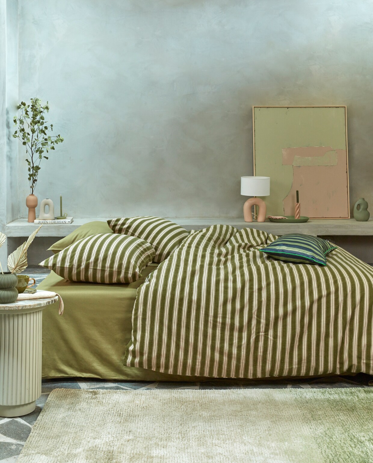 Katoenflanellen dekbedovertrek Pyjamas, 140×200/220 cm € 74,95, 200×200/220 cm € 139,95, 240×200/220 cm € 149,95 en 260×200/220 cm € 169,95, polyestersatijnen kussen met bies Pyjamas, 40×60 cm € 39,95.M.m.v. nordal.eu (marmeren bijzettafel Erie), hkliving.nl (schilderij), paviljoennoord.com (mok, bord). Overig privébezit. vtwonen 13-2022 | productie Tanja Saarberg | styling Danielle Verheul | fotografie Richard Smit