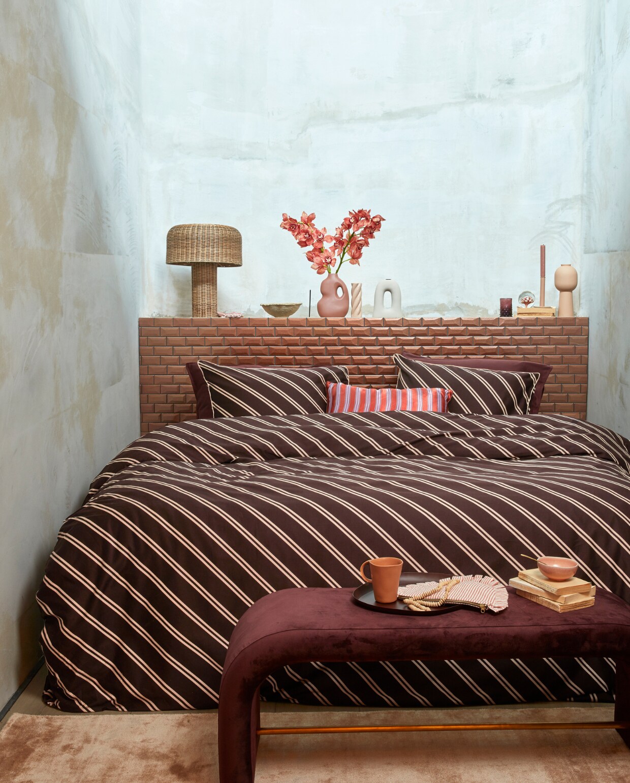 Katoensatijnen dekbedovertrek Diagonal, 140×200/220 cm € 79,95, 200×200/220 cm € 149,95, 240×200/220 cm € 159,95, 260×200/220 cm € 179,95, satijnen kussen met bies Pyjamas, 40×60 cm € 39,95.M.m.v. nordal.eu (bank Douro), paviljoennoord.com (mok, schaal). vtwonen 13-2022 | productie Tanja Saarberg | styling Danielle Verheul | fotografie Richard Smit