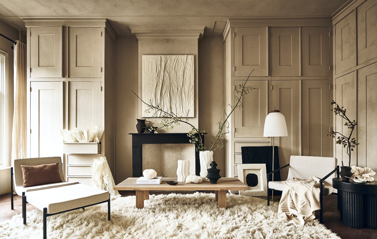 Crèmekleurige fauteuil Curve van Serax € 998,-, crèmekleurige fauteuil Curve van Serax met armleuningen € 1055,-, hocker Curve van Serax € 504,- (shop.vtwonen.nl). Bruin kussen € 69,-, houten lepel op zwarte tafel € 24,50, witte schotel op zwarte tafel € 22,50 (sukha.nl). Papieren kunst tegen kast € 125,-, moerbeipapieren kunst op zwarte tafel € 795,- (elsavisser.com). Bruine vaas op schouw € 39,99, bruin schoteltje op salontafel € 17,99, bruine vaas op zwarte tafel € 22,99 (zarahome.com). Wit kunstwerk, 100×120 cm, prijs op aanvraag, zwart kunstwerk Water &amp; Cracked Mud, 60×80 cm € 990,-, witte vaas op salontafel Vase Sculpture Small € 480,- (studio-harte.com). Zwart bakje op schouw € 19,99, zwarte vaas op salontafel € 24,99 (hm.com). Witte siervorm op tafel € 295,- (taxidermy.nl). Witte vaas links op tafel € 135,-, (fermliving.com). Stenen witte bol, prijs op aanvraag, houten salontafel vanaf € 1449,- (studiohenk.nl). Wit vloerkleed, 235×350 cm € 1395,-, wit plaid € 99,- (eijerkamp.nl). Vloerlamp vanaf € 840,- (bolia.com). Zwarte tafel € 449,-, boeken € 22,- (aedamanthony.nl). Wit kunstwerk met zwarte ronding, prijs op aanvraag (@ansdekruyf). Muurkleur en vloer onbekend. Overig privébezit. vtwonen 1-2023 | styling liza wassenaar | fotografie sjoerd eickmans