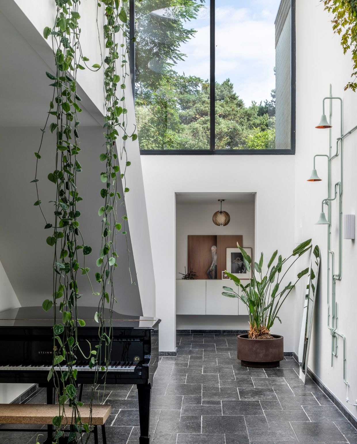 Muurverf schrobvaste RAL 9010 Flexa. Balustrade met hangplanten eigen ontwerp. Gipsen object met bloemen Studio Amber Isabel. NEE | vtwonen 07-2022 | productie CocoFeatures | styling Brenda van Roekel - Studio Amber Isabel en Lotje Deinum | fotografie Denise Zwijnen | tekst Saskia Borst
