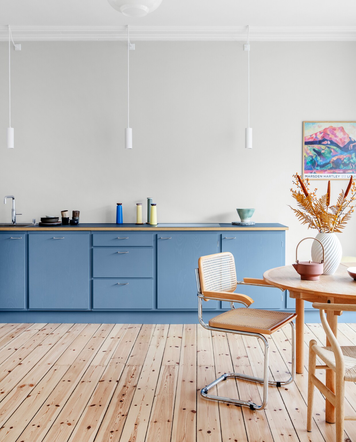 Muurverf Morgendis van Jotun. Keuken Stilleben Architects. Peper- en zoutstel Hay. Tafel Øresund van Børge Mogensen. Vaas Morsø. Theepot Skagerrak og Stilleben. Stoelen Hans Wegner en Marcel Breuer. Originele houten vloer, gerestaureerd. Hanglampen Light-Point. Overig herkomst onbekend. vtwonen 09-2022 | productie Living Inside | styling Rikke Graff Juel | fotografie Christina Kayser O.
