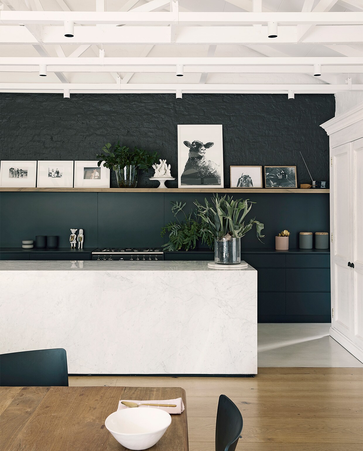 Kleur op de wand: soortgelijk Off Black van vtwonen via Karwei. Eetkamertafel op maat gemaakt met vintage poten en nieuw blad. Stoelen Spazio. Marmeren keukeneiland op maat gemaakt, soortgelijk By Sensa en Grillo. Kast kringloopwinkel, soortgelijk Old Basics. Overig onbekend. NEE | vtwonen binnenkijken special 2021 | productie Bureaux | styling Sven Alberding | fotografie Elsa Young