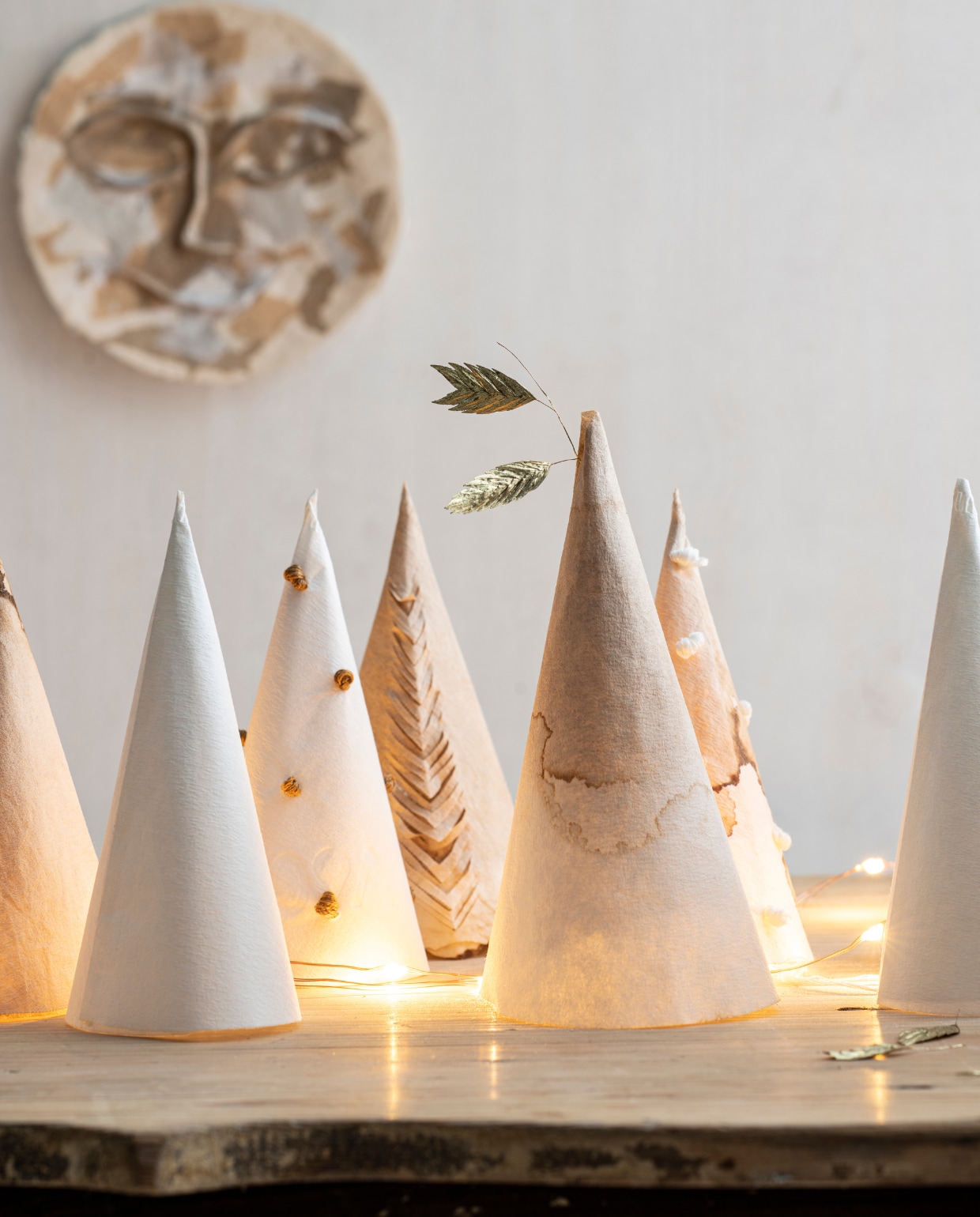 Papier-maché gezicht uit de Moods limited collection, per stuk € 54,95 (). Koperdraad lichtsnoer € 4,50 (). Kerstornament (woodchuck.nl). Overig privébezit. vtwonen special Kerst Couture 12-2022 | styling: Janneke Peters | fotografie Louis Lemaire