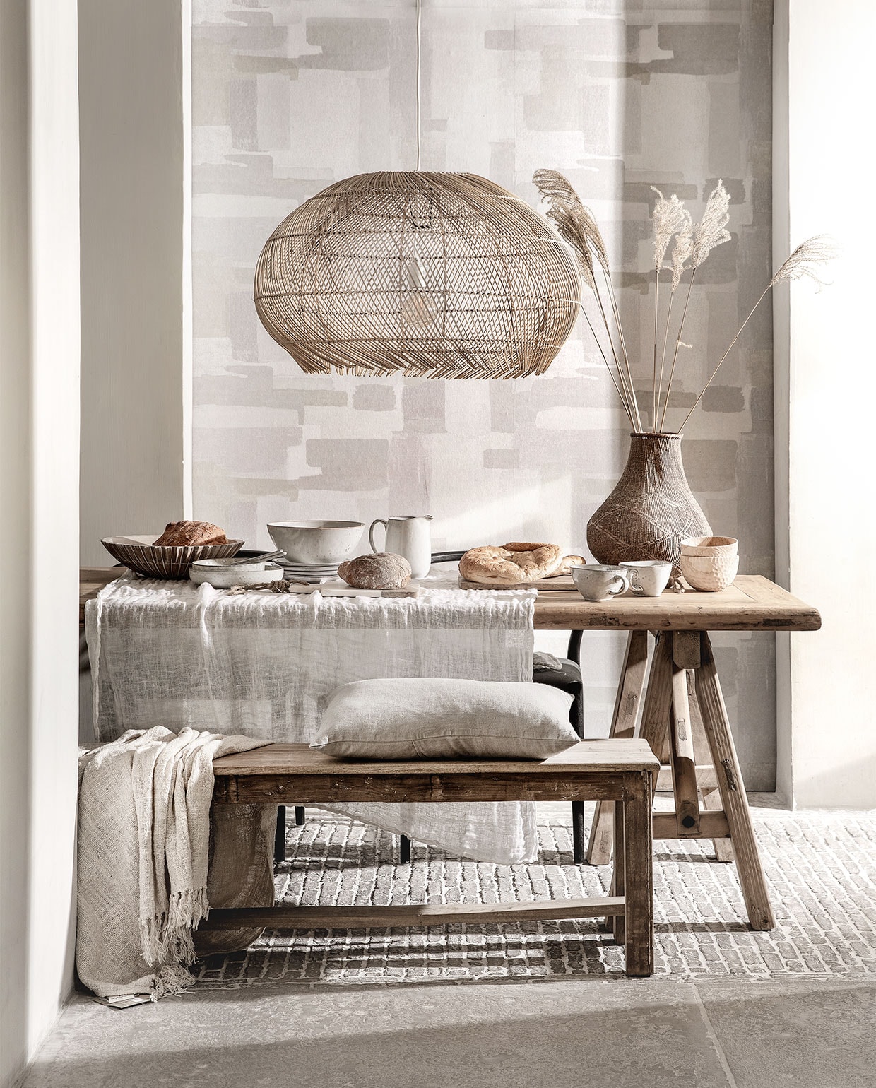 Behang Lino, 106 cm breed per meter € 15,95 (eijffinger.com). Rieten hanglamp € 229,95 (manggisliving.nl). Houten whitewash schaal Marseille € 92,50 (mrsbloom.nl). Servies Broste Copenhagen; schalen v.a. € 19,95, grote schaal € 39,95, kan € 33,95, bord € 11,95, grote kom met oor € 15,95, bewerkte houten schaaltjes per stuk € 39,95 (loftloft.nl). Linnen kussen € 49,95, eettafel van oud hout, 260×90 cm € 1795,-, oud teakhouten bank 176 cm breed € 245,- (hetkabinet.nl). Grof geweven plaid € 87,95 (heinshome.nl). Vaas € 69,- (stylexclusief.nl). vtwonen special 03-2019 | styling Moniek Visser | fotografie Peggy Janssen