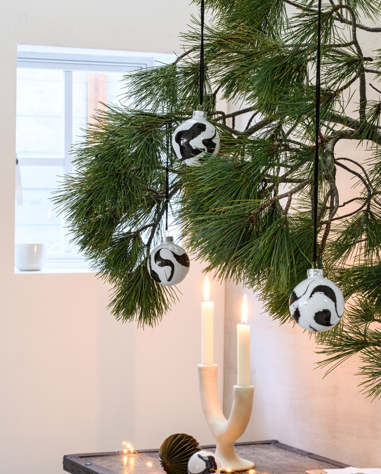 Kandelaar two arms ecomix van Urban Nature Culture € 39,99 (fonq.nl). Papieren honeycomb kerstbal € 2,69 (intratuin.nl). Dinerkaars € 0,95 (dille-kamille.nl). styling Kelly van Gendt | fotografie Louis Lemaire