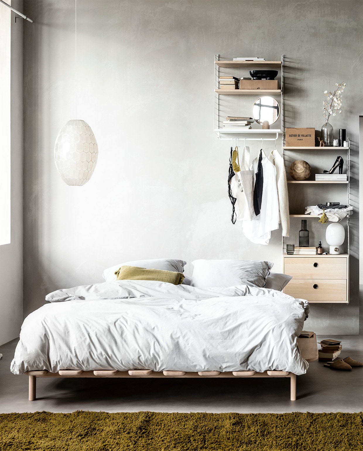Muurverf kleur North, per liter € 30,- (bauwerkcolour.com). Wandsysteem met witte draadstalen panelen en planken, deuren en werkblad in kleur Ash, vanaf € 1983,- (stringfurniture.com). Vloer Novilon kleur Beton van vtwonen, 200 cm of 400 cm breed, exclusief installeren per m² € 28,95 (vtwonen.nl/vtwonen-collectie). Gordijn Dazer van Kinnasand, 320 cm hoog per meter € 125,-, witte houten vlinderstoel € 421,- ronde houten opberger met deksel € 165,- (coosdewitwonen.nl). Parelmoeren hanglamp € 129,-, ronde spiegel op eikenhouten poot € 139,-, canvas tas € 19,90, bruin flesje olie € 12,90, eikenhouten lijst vanaf € 26,90, doosjes met knoopjessluiting per stuk vanaf € 15,50, plastic kratten per stuk vanaf € 15,50, witte kartonnen opbergers per stuk € 9,90, zachtgrijze leren tas met bruin leren koord € 129,90 (letoile.store). Massief beukenhouten bed Modest vanaf € 1390,- (loof.nl). Dekbedovertrek met bijpassende slopen van percal katoen in kleur Misty Grey vanaf € 99,95 (yumeko.nl). Sierkussen € 29,95, raffia instappers € 49,95 (zarahome.com). Okergeel berberkleed, verkrijgbaar in elke maat en kleur, 220×340 cm € 1875,- (paullelieveld.com). Zwarte ovale marmeren schaal op poten van Ferm Living € 77,35, grijze glazen karaf van Ferm Living € 35,-, set van 4 € 39,- tafellamp met grijze betonnen poot van Menu € 179,-, tafellamp met gebroken wit onderstel van Menu € 170,99 (vtwonen.nl). Zwart houten object in cilindervorm € 15,95 zwart houten object in puntvorm € 25,95, zwart houten opbergschaaltje € 12,95 (loods5.nl). Metalen brillenkoker € 16,95, grijze fluwelen toilettas met gele kwast € 19,95 (maisonnl.com). Overig privébezit. vtwonen 11-2019 | styling Danielle Verheul | fotografie Sjoerd Eickmans