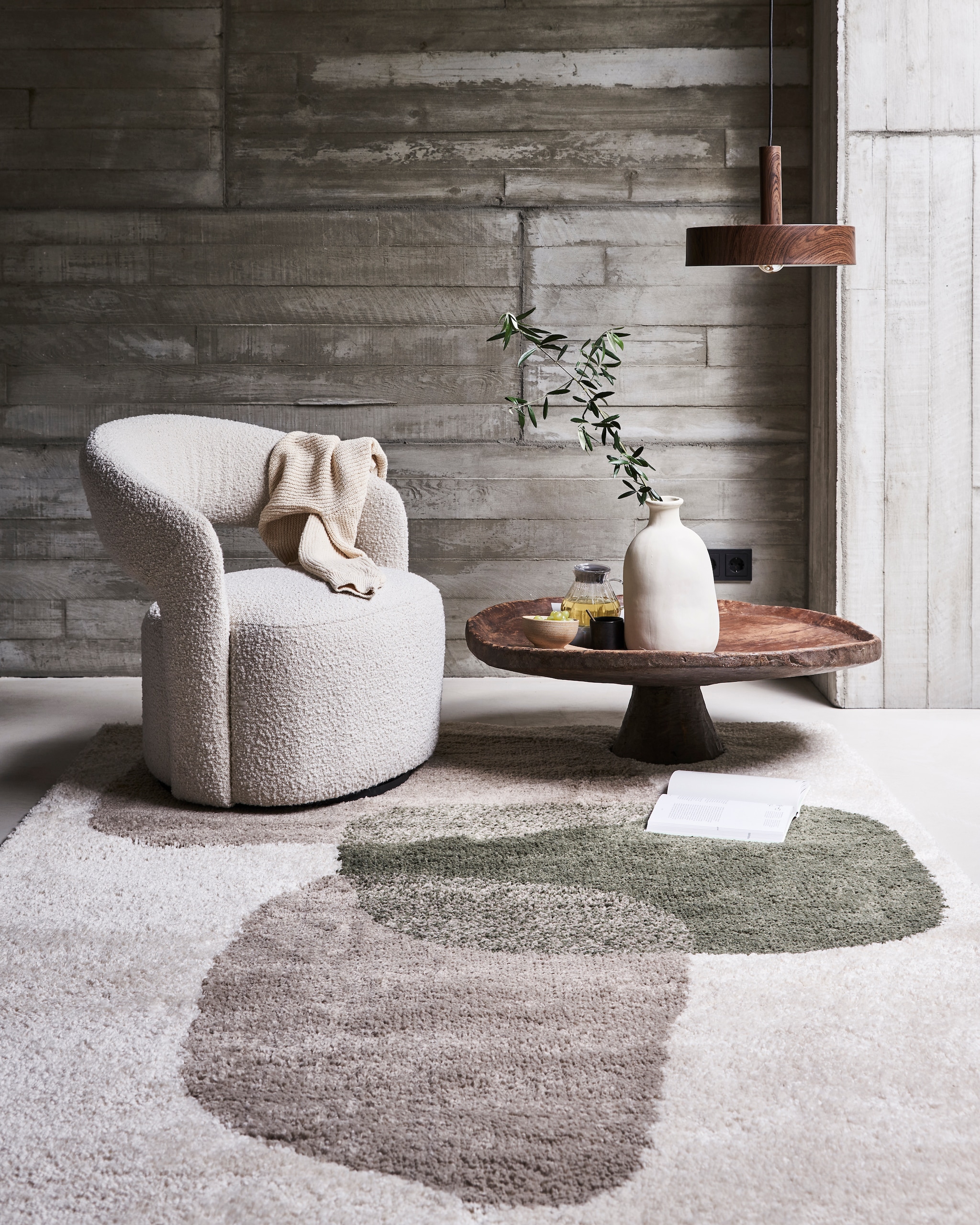 Hanglamp Woody van bruin metaal, 35×8 cm (Øxh) exclusief lichtbron € 99,-, (ook verkrijgbaar in formaat 27×8 (Øxh € 79,99). Vloerkleed Stepping Stones, 160×230 cm € 179,-. M.m.v. sofacompany.com (fauteuil), couleurlocale.eu (salontafel), vtwonen.nl (vaas). Overig privébezit JA | vtwonen 11-2021 | styling Marlies Does | fotografie Bart Brussee | productie Tanja Saarberg